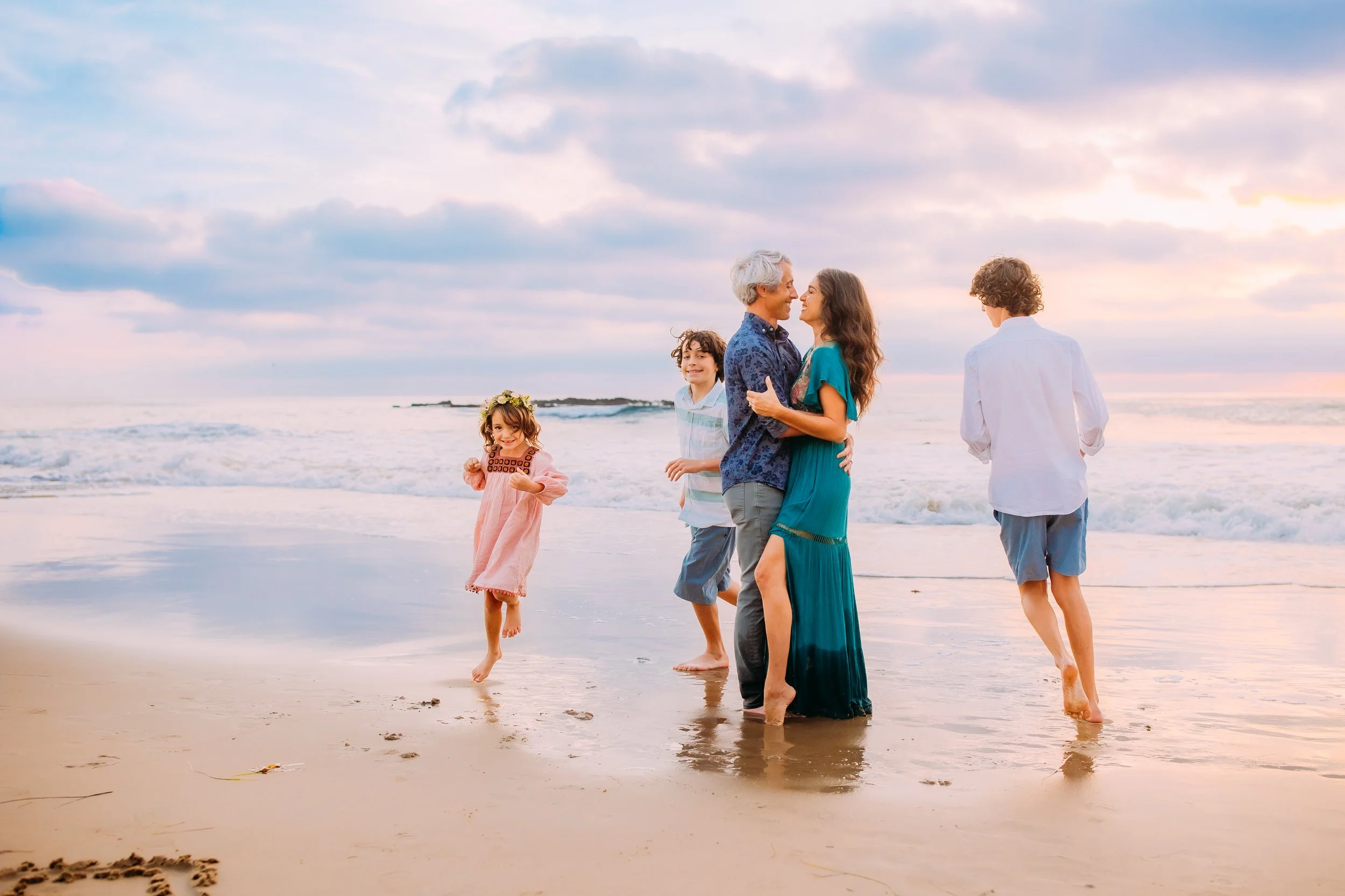 kids running around their parents during a family photoshoot in Newport Beach, California