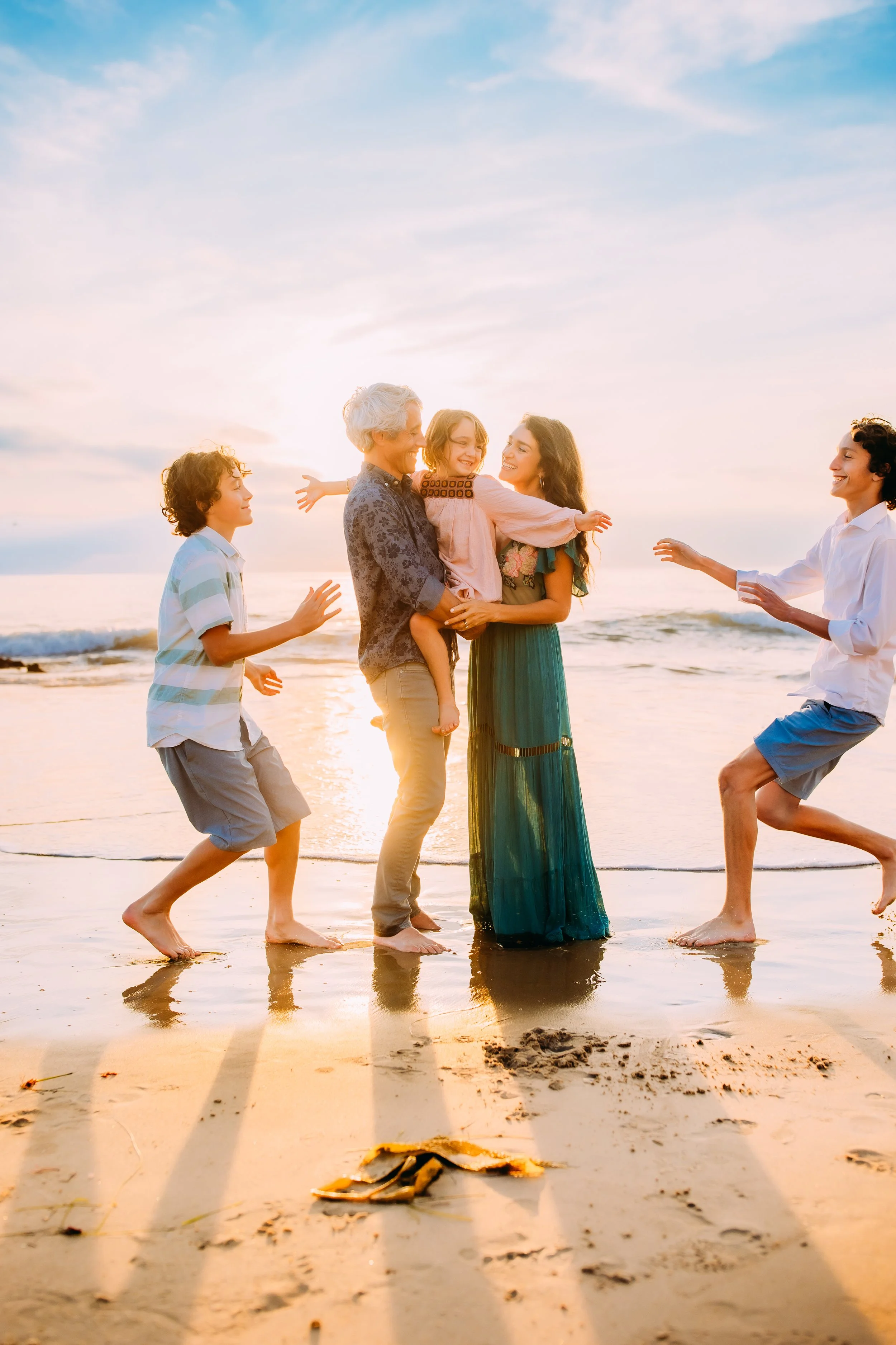 familiy playing at the beach during their photoshoot in Newport Beach, California