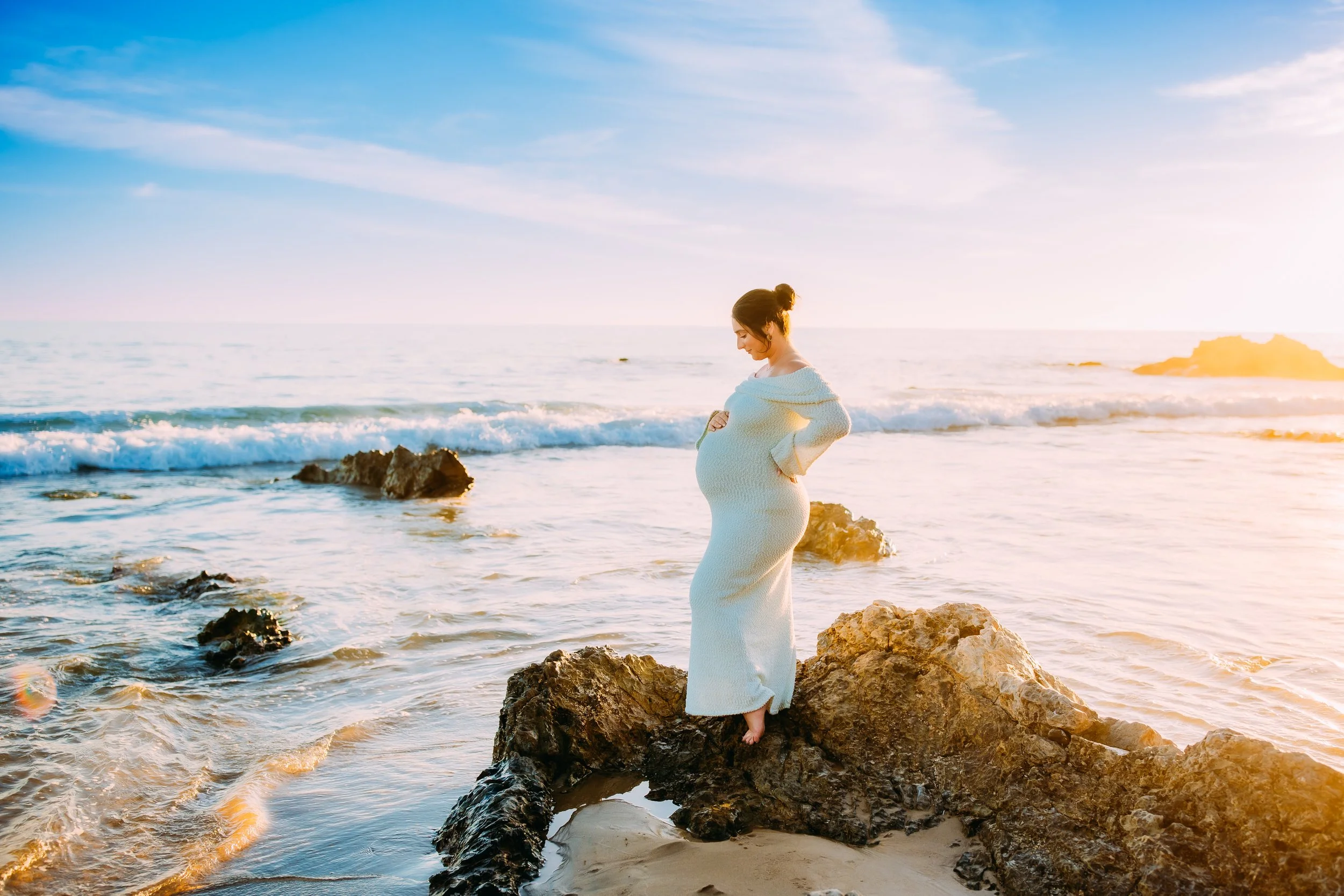 Maternity photos in Newport Beach at sunset with glowing mom on beach