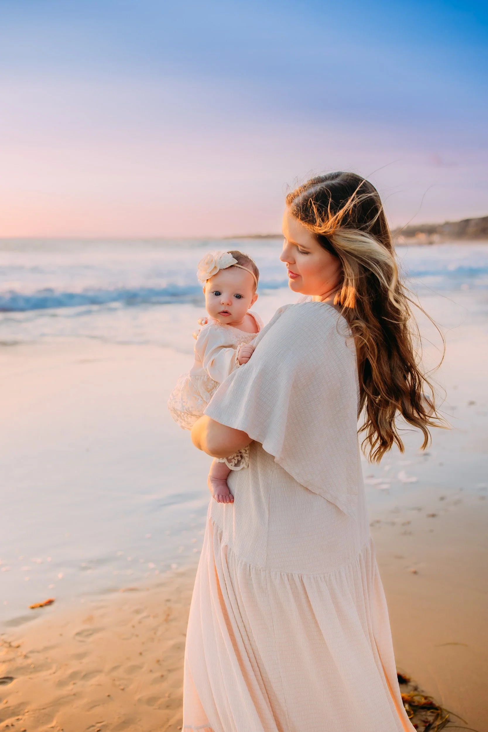 mom gazing at her baby girl during their family photoshoot in Newport Beach, CA