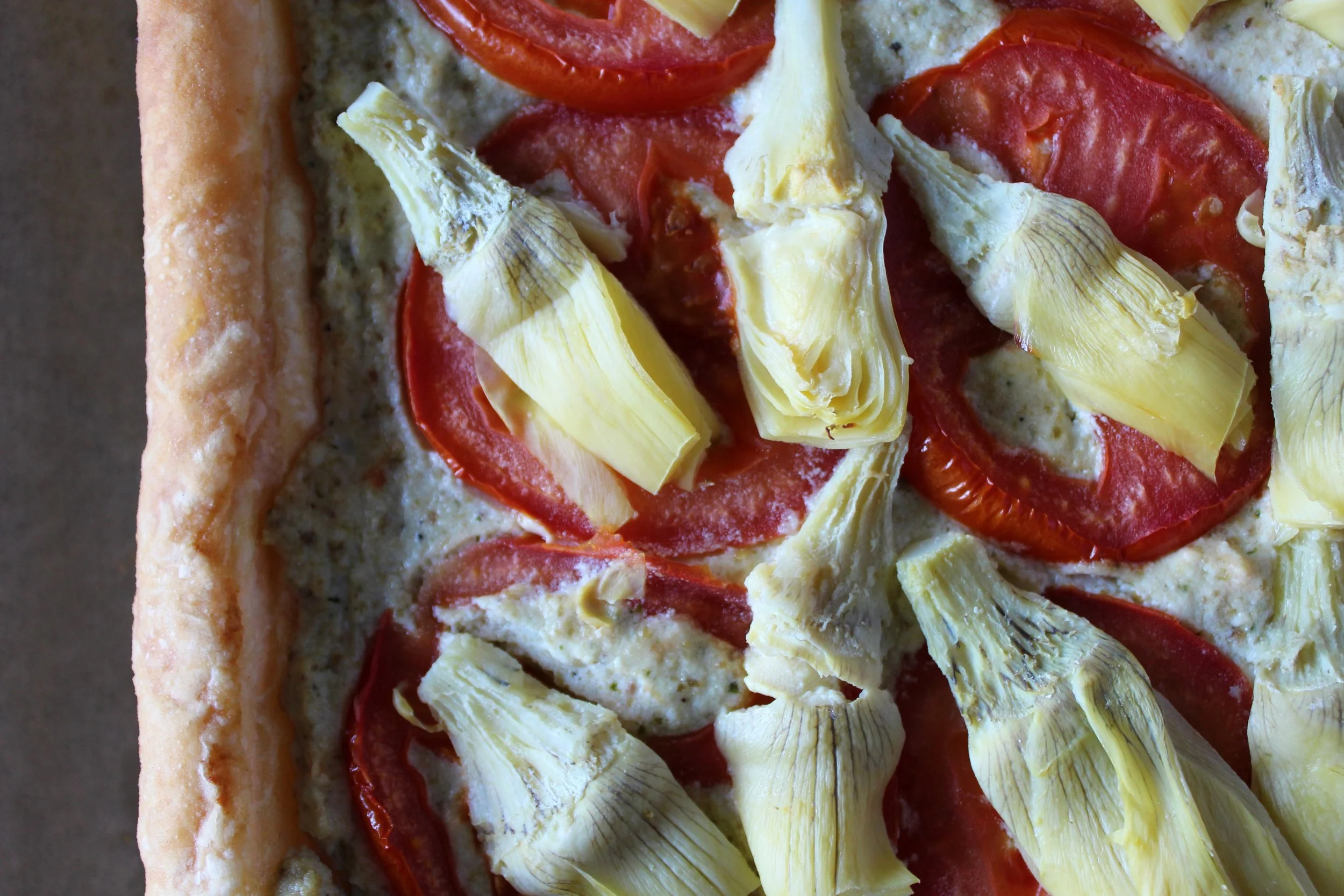 Tomato and artichoke puff pastry with pesto ricotta cheese