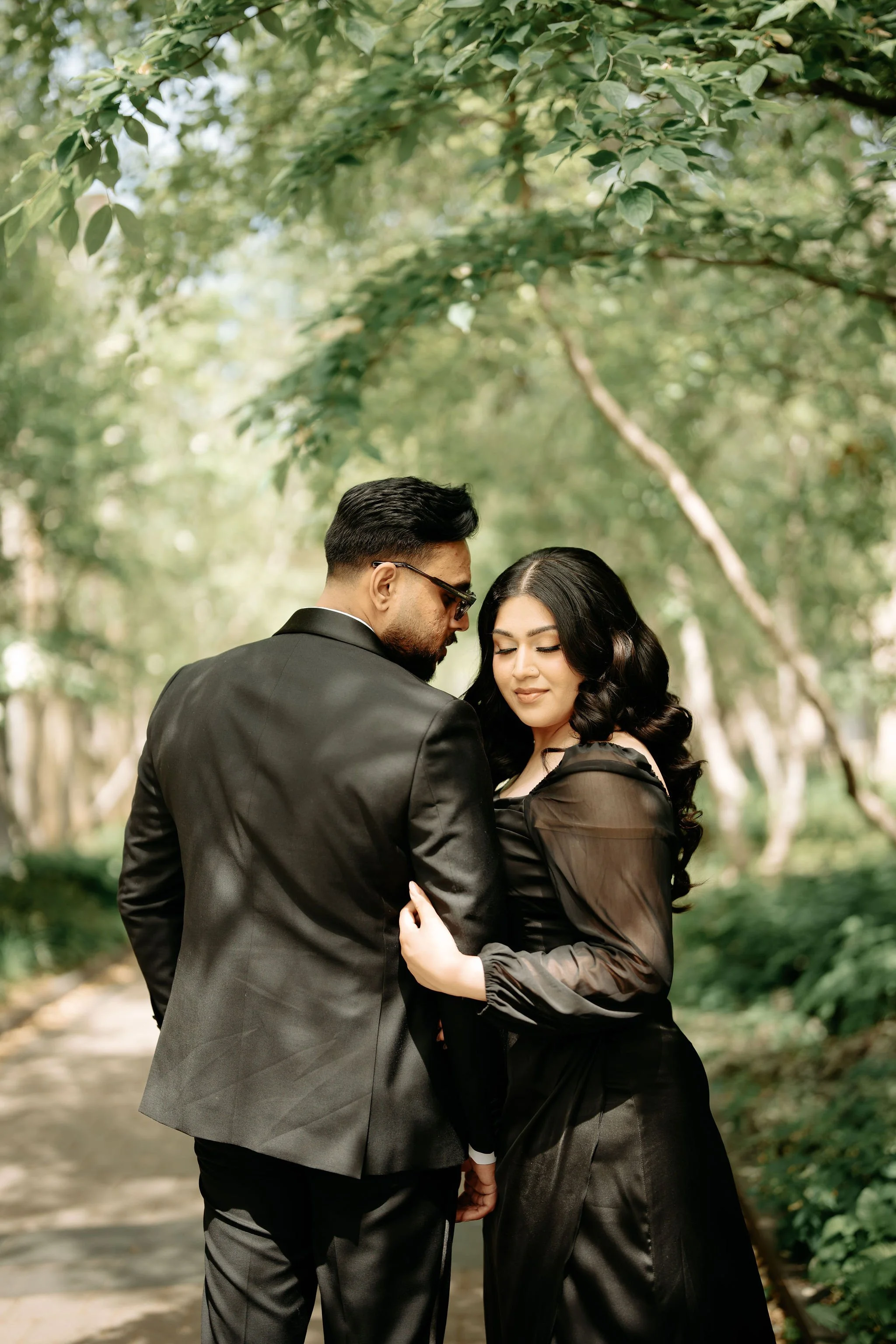 Muslim wedding photographer Toronto – candid embrace in outdoor greenery during engagement session.