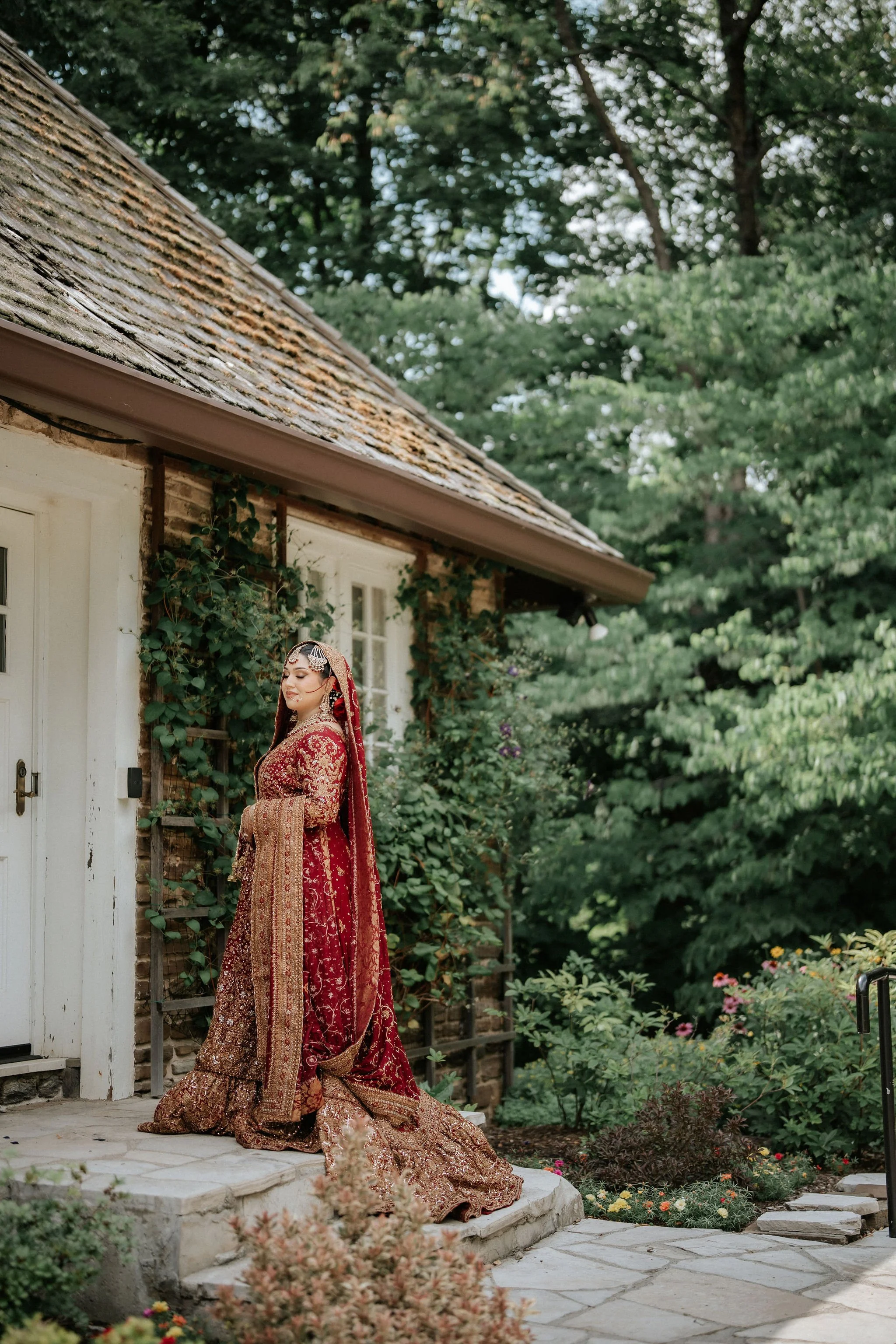 Toronto Muslim bridal photography – bride in red lehenga posing outdoors before the wedding ceremony.