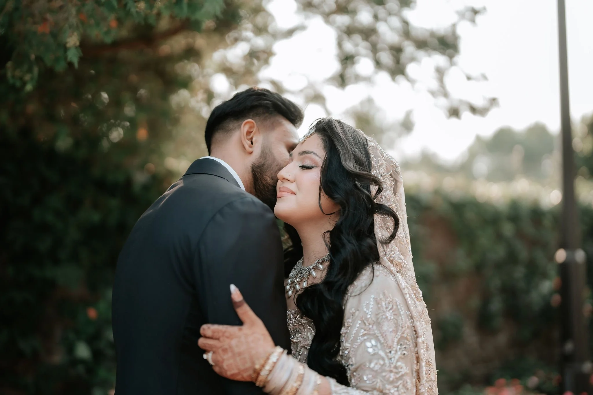 Emotional Muslim wedding photography Toronto – groom kissing bride’s forehead during candid portrait.