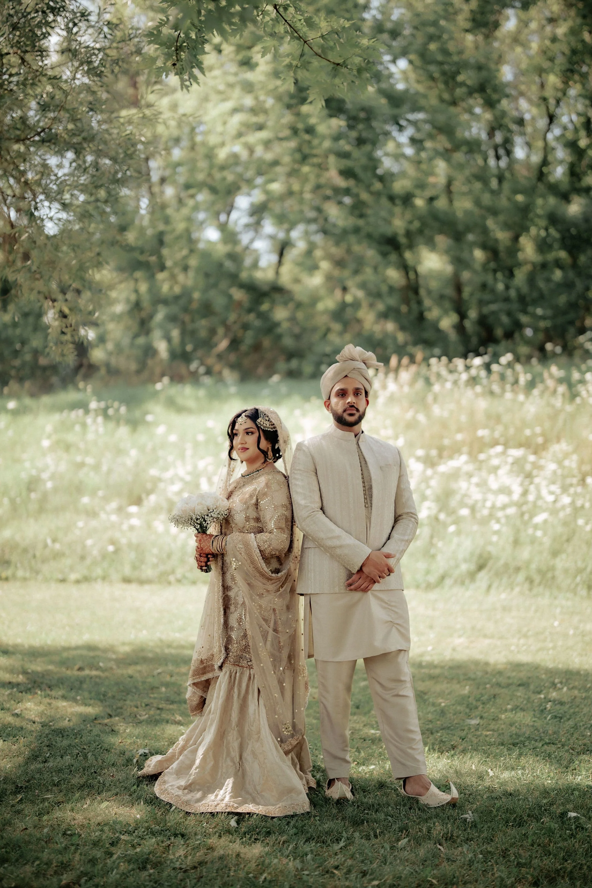 Candid Muslim wedding photography Toronto – bride and groom portraits under lush green trees.