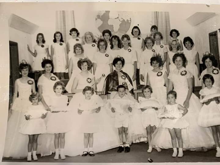 Doris’ daughter explained, “My mom is 3rd row far right if you count the row with the crown bearers. I am in the middle with my brother, Randy, in front. Carolyn Weatherford was there to give me the scepter.”