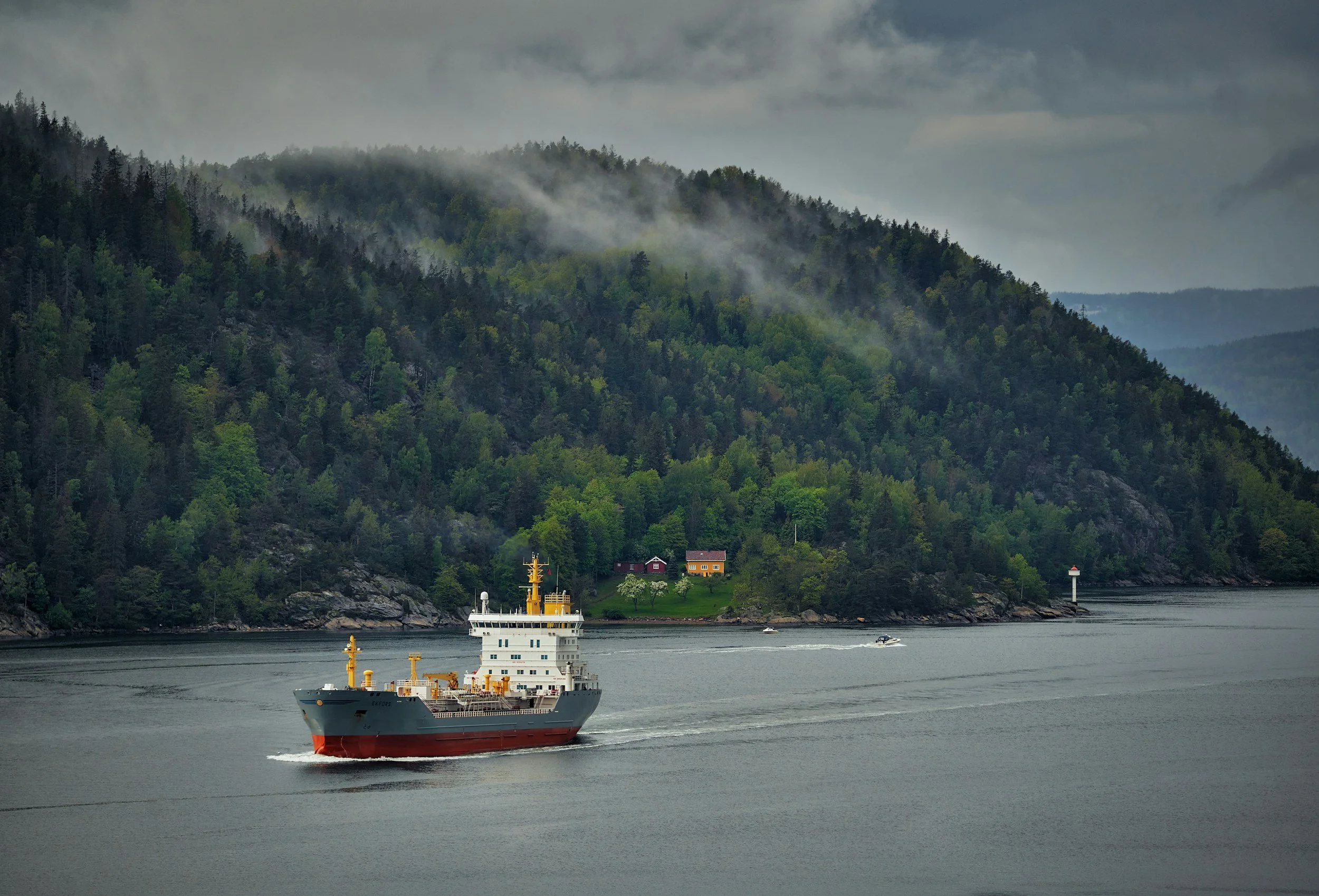 Photo of shipping vessel with green hills in the bacground