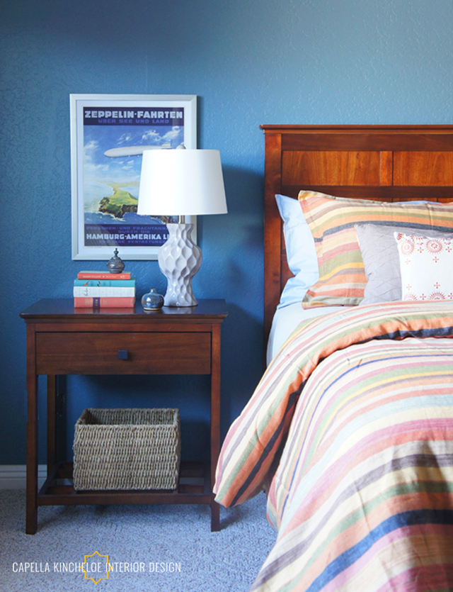 Colorful guest bedroom, travel poster art, blue walls