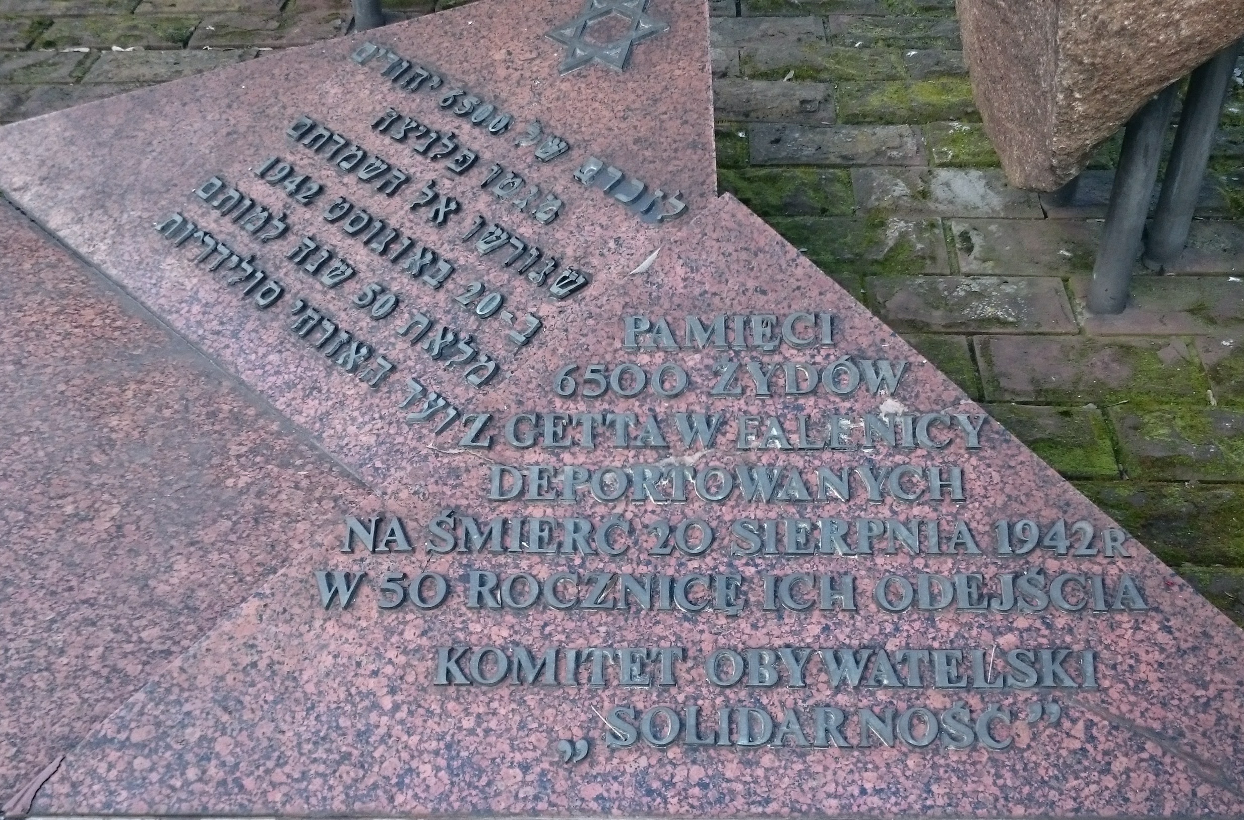 You can see it in Hebrew and Polish. Exact translation into English: Memorial of the 6500 Jews from the ghetto in Falenica (a region of Warsaw) who were deported to death on 20 August, 1942. At the 50th anniversary of their leaving. Put up by the civic committee "Solidarity".
