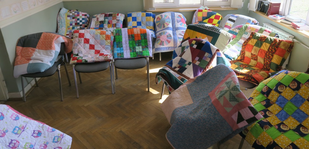 I draped quilts over chairs and had about 60 out at time for people to choose from. When some were taken, I'd replace them with others in order to keep a good selection available. People would walk through and choose what appealed to them.