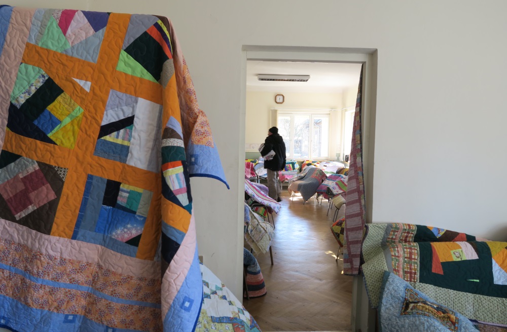Believe it or not, this bright orangish yellow crazy squares ones were originally lap size. I added borders to the edges and make them into the sizes I needed. While I personally thought they were ugly, they were almost all chosen. Here is a man walking away with his quilt under his arm.