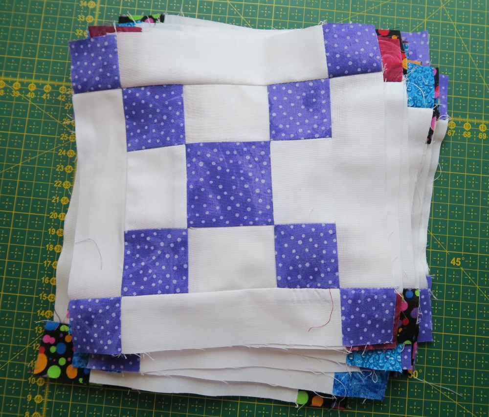 I made 22 of these blocks in various brights. I need 56, so in a couple more big sewing sessions, I should have them all done.