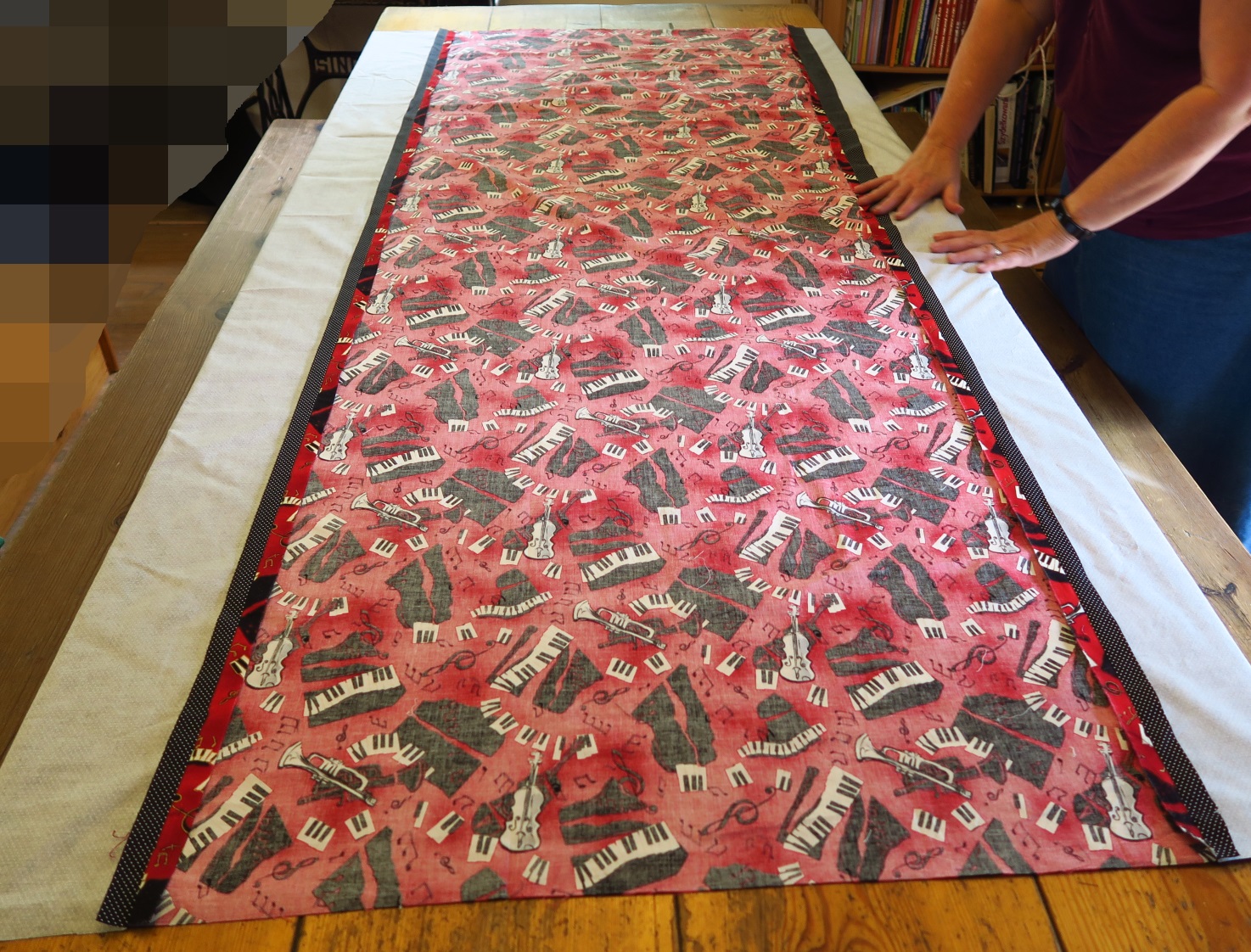 She pieced a piece of red music fabric to two polka dot pieces (black) in order to make a backing the right size. She wanted to center the backing with the top, so we matched centers as we laid it out. I guess we'll check it at the end and see how accurate we got it (after washing).
