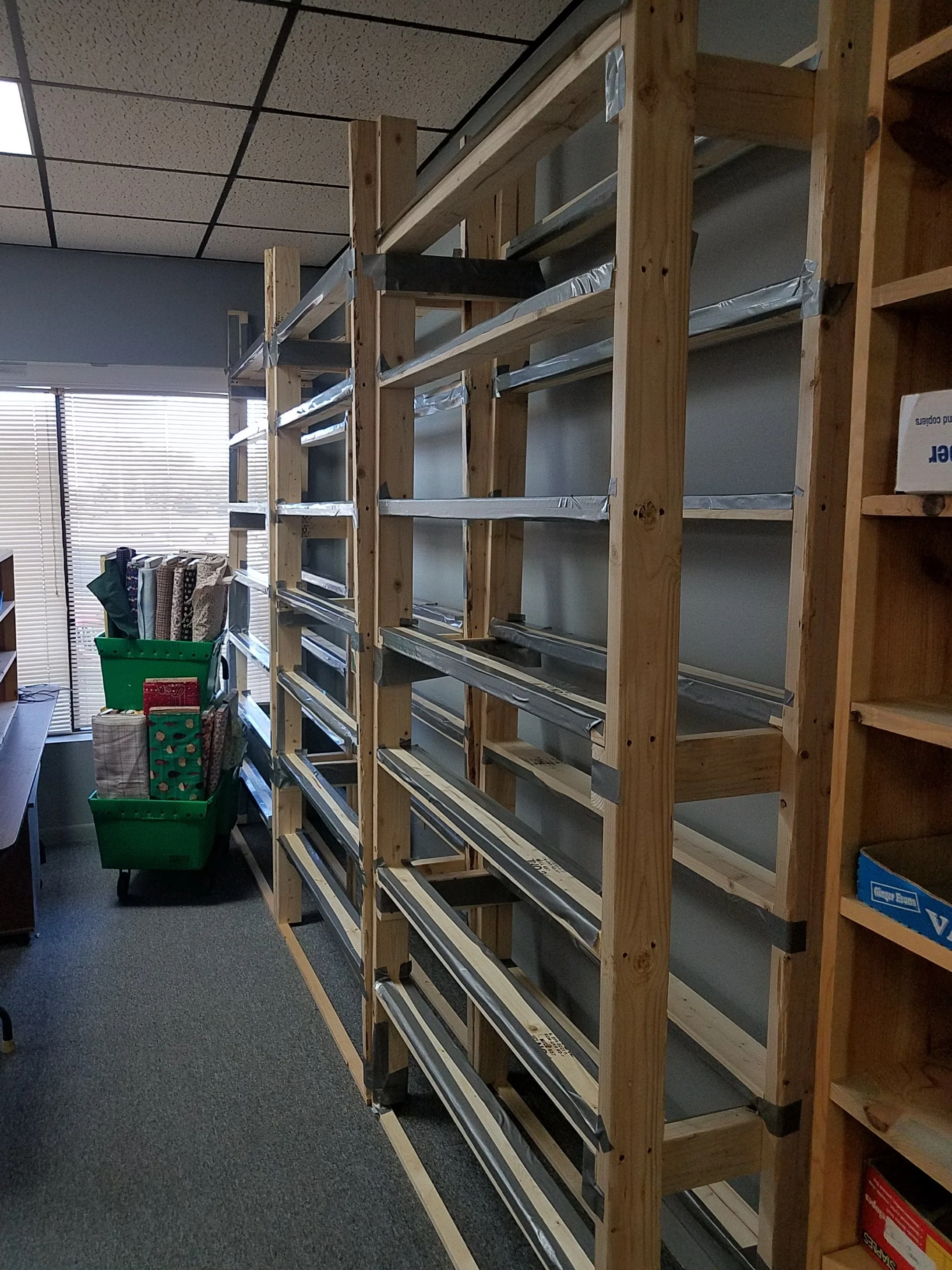 Here are my shelves, ready for filling and the first of the fabrics, ready to be put up! Oops. Forgot a tall step stool. I had to buy one of those when I was getting more duct tape!