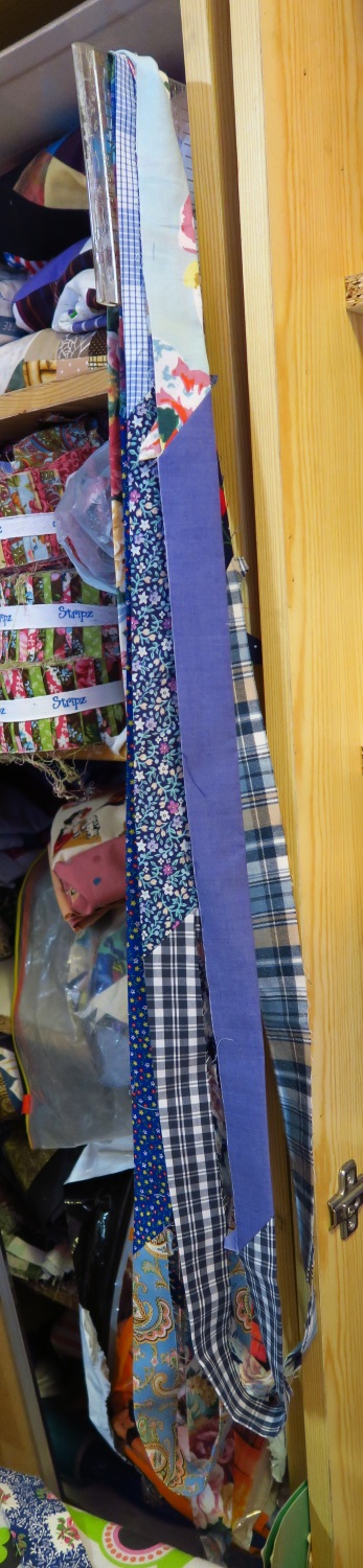 Bindings in process. I have them hanging here on a ruler. I'll probably attach them to a hanger and let them hang up until the tops are quilted. I use 2.5" strips for this kind of binding.