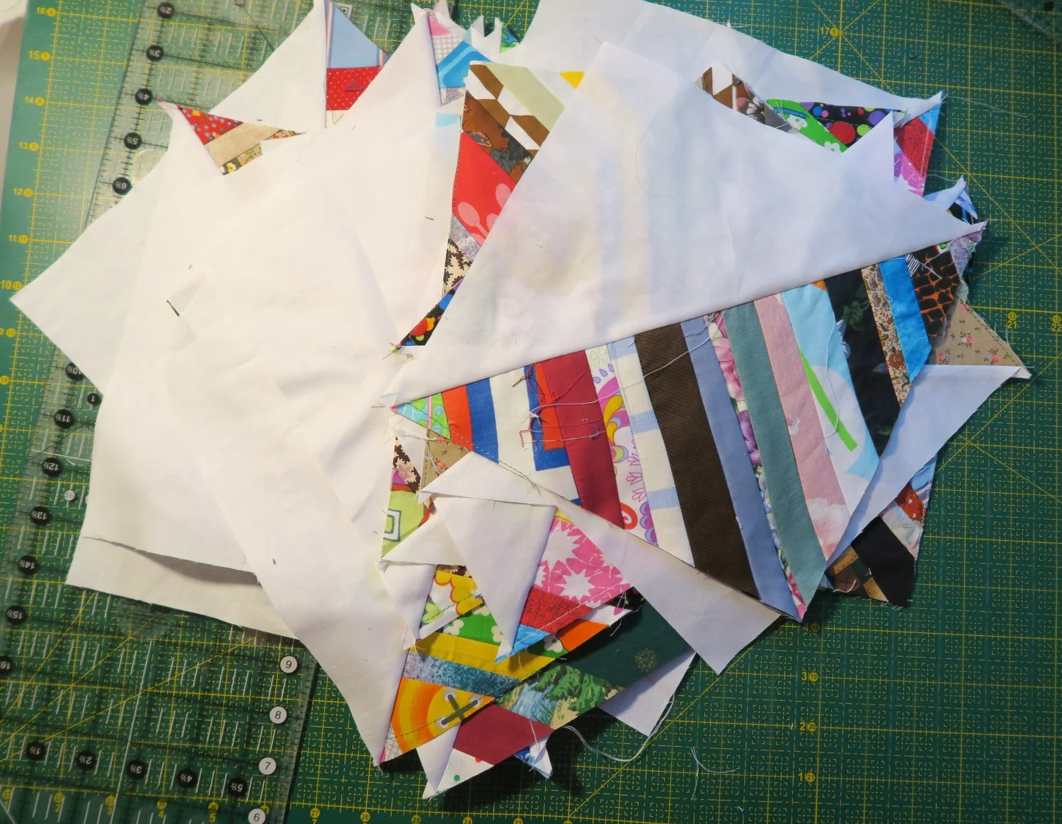 My blocks started out at 9.5". I then sewed a white 9.5" square to a string block, cut in half and now I had 2 HST that looked like above. I trimmed to 9" and the blocks will finish in the quilt at 8.5" Kind of a weird size. I know.