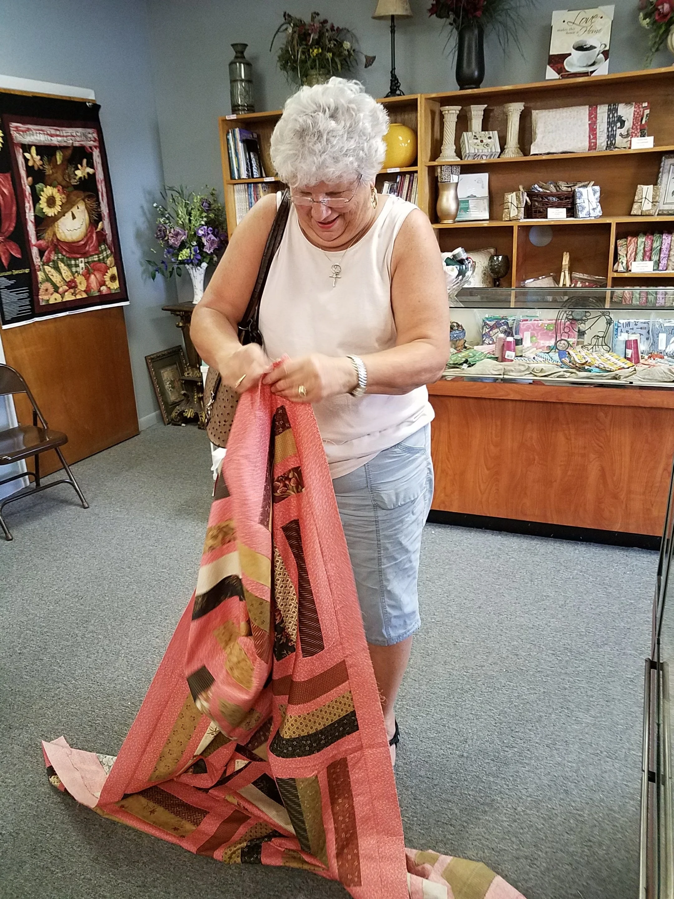 Helen didn't want me to photograph her head above her quilt, so I snagged one while she was folding it up! Good job, Helen!