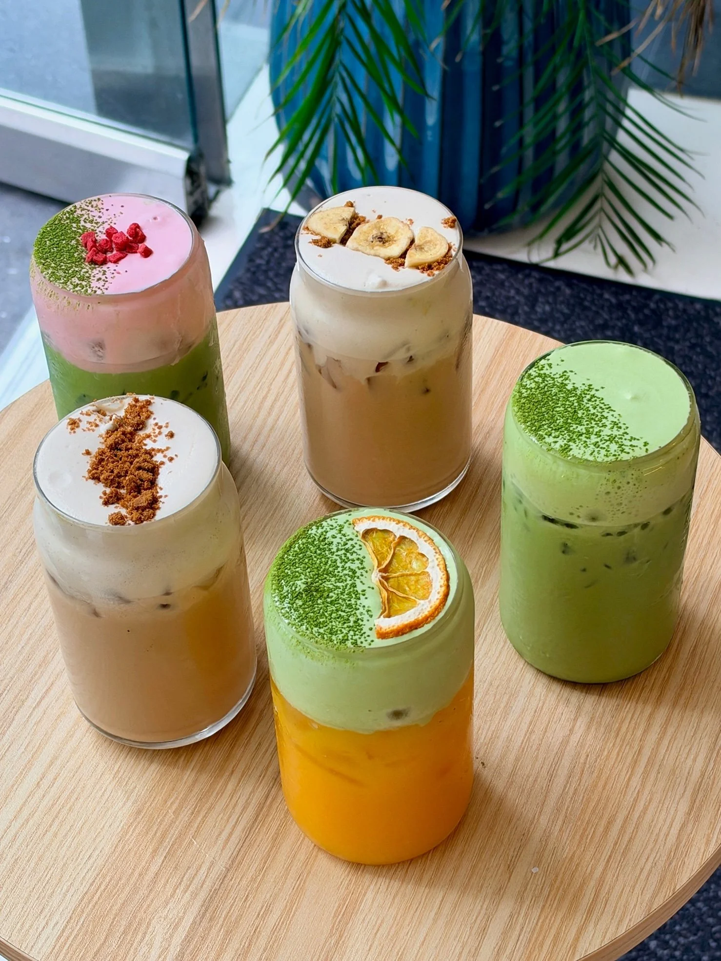Five Origin Lab matcha drinks on a wooden table