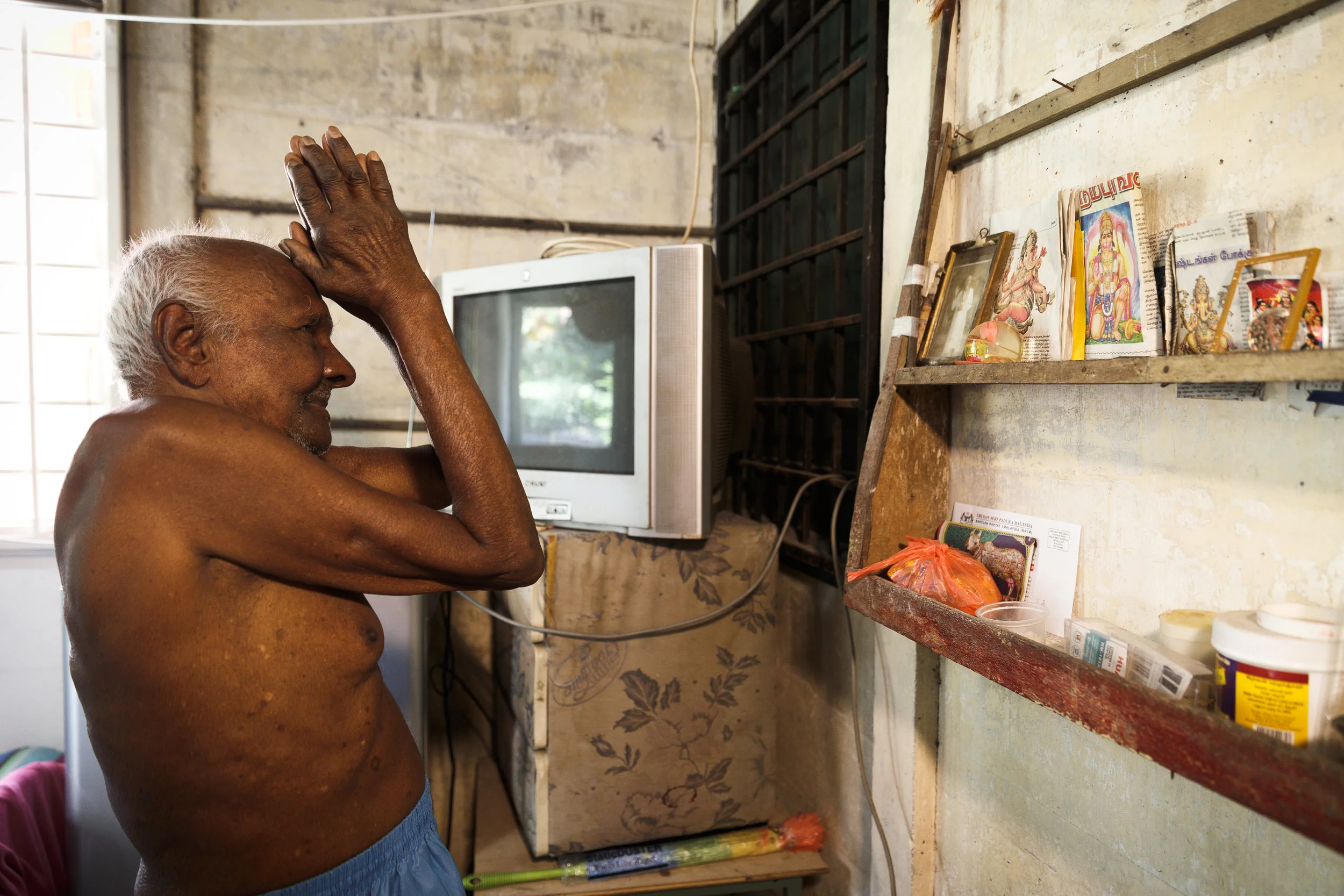 Krishnan praying to his Hindu deities. (photo by Mango Loke)