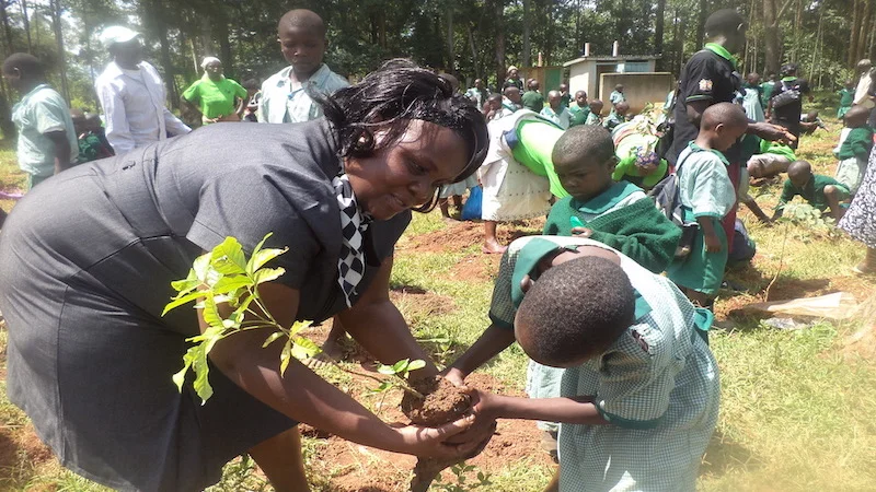 Violet Shivutse plants trees with students in Kenya (Photo: Huairou Commission)