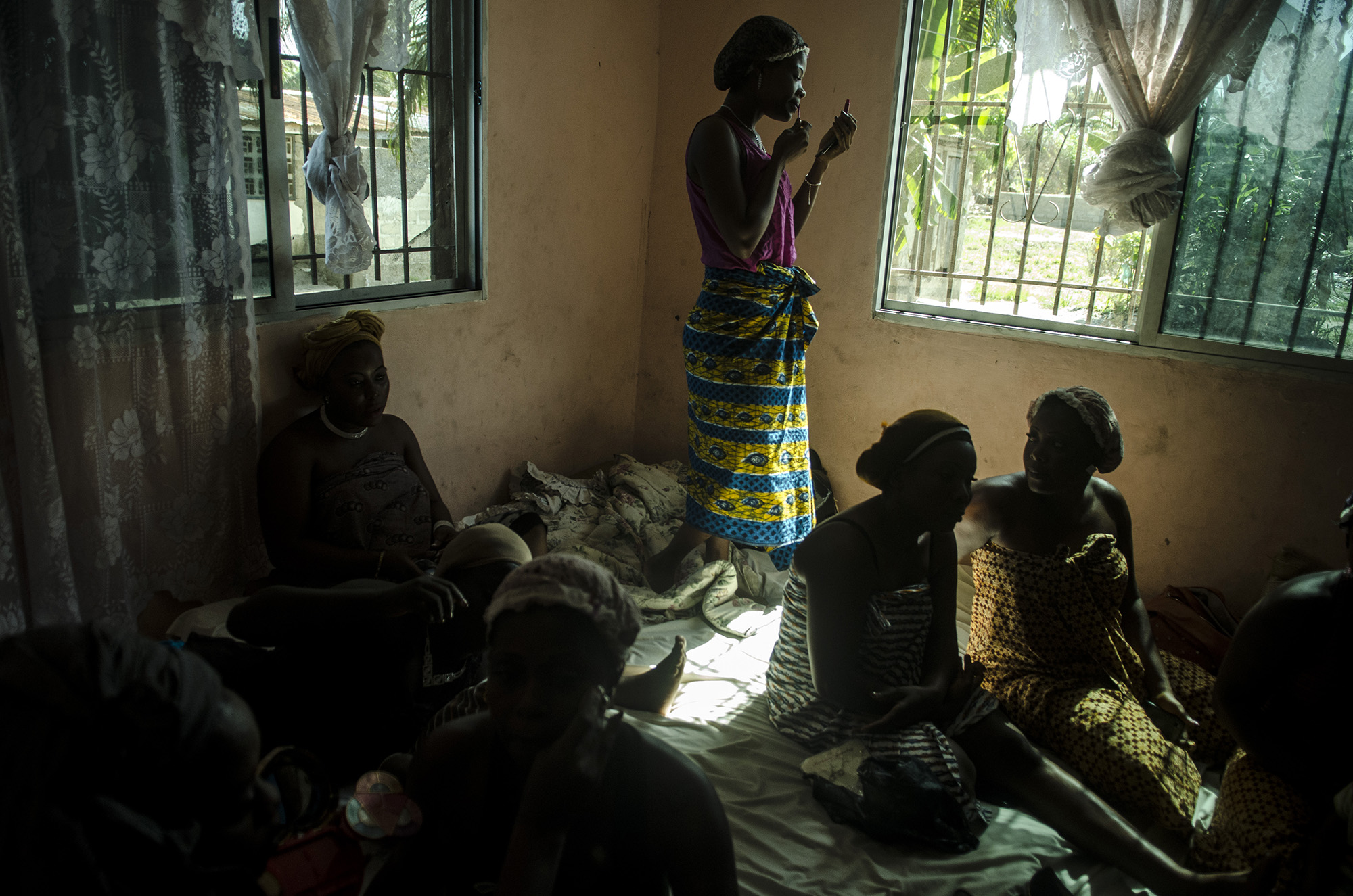  A woman puts on makeup while getting ready for her friend's wedding in Monrovia, Liberia.&nbsp; 