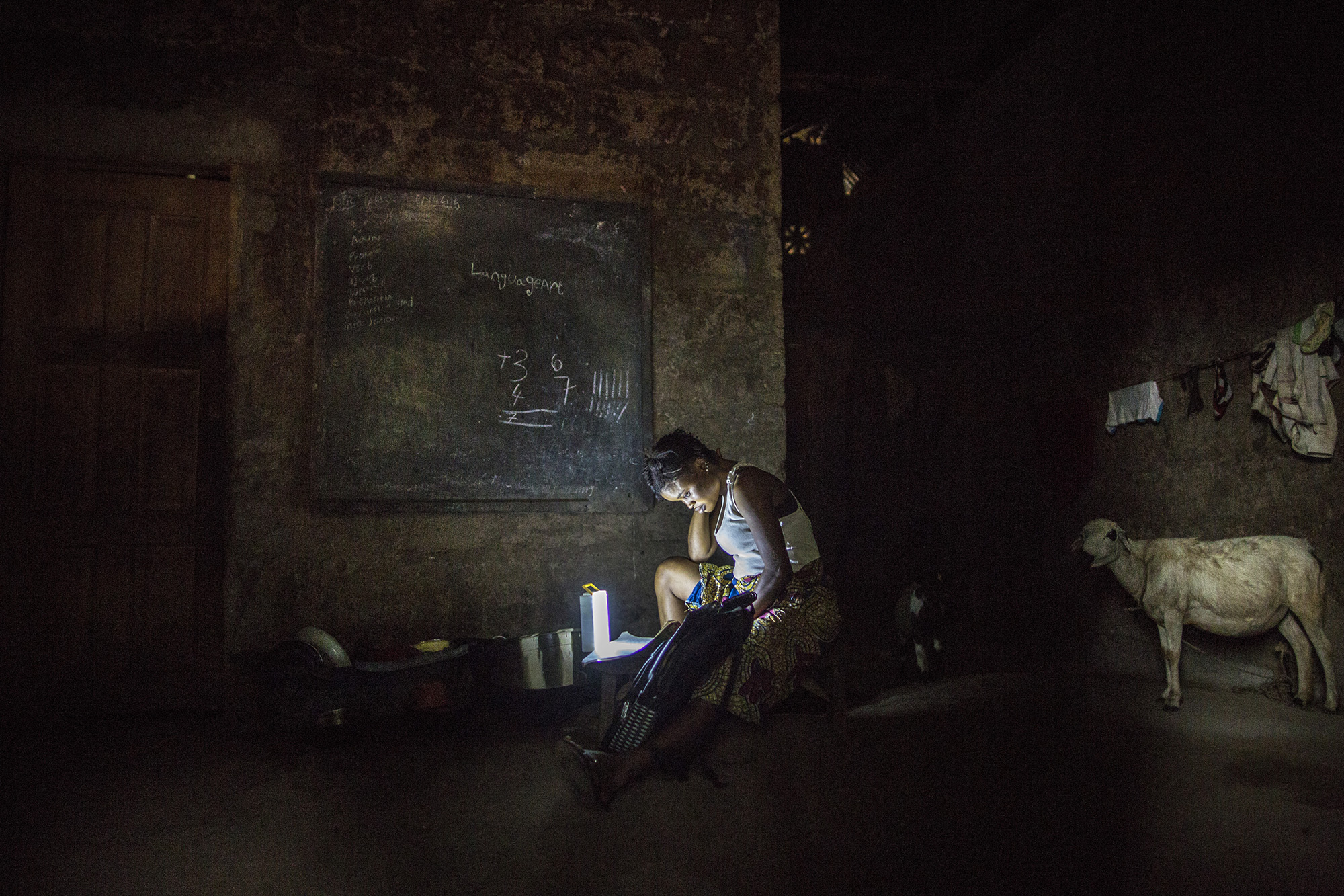 Mariatu Bangura, 18, of Rokupr, studies at her home in the evening. 