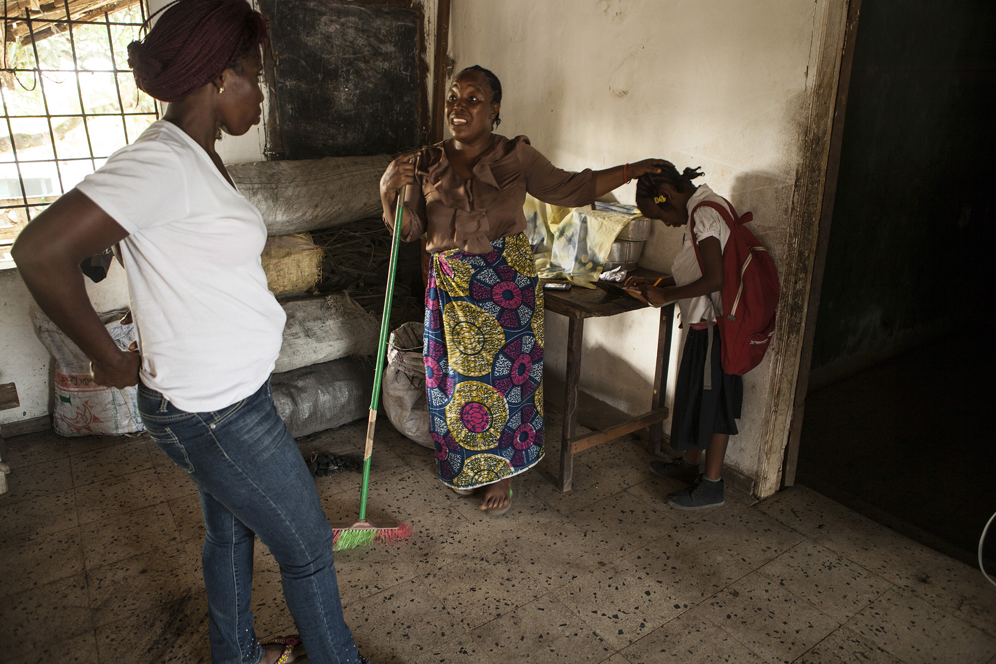 Fatu Johnson, pictured above on the left, speaks with Martu Weefor, Mercy's foster mother, at her house to let her know that Mercy was having a hard time with writing and completing her assignments. Martu asked the teachers to be patient with Mercy