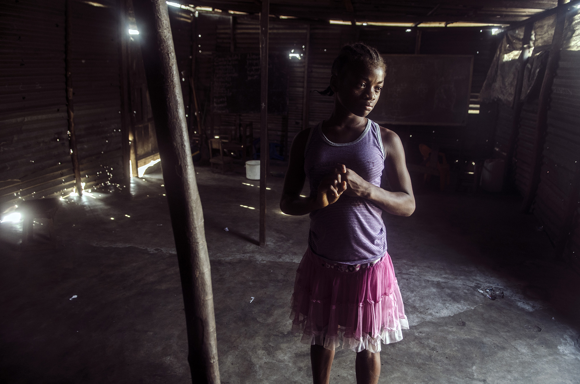  Albernita, a student at the More Than Me Academy in Monrovia, stands inside a school near where she lives in West Point.  