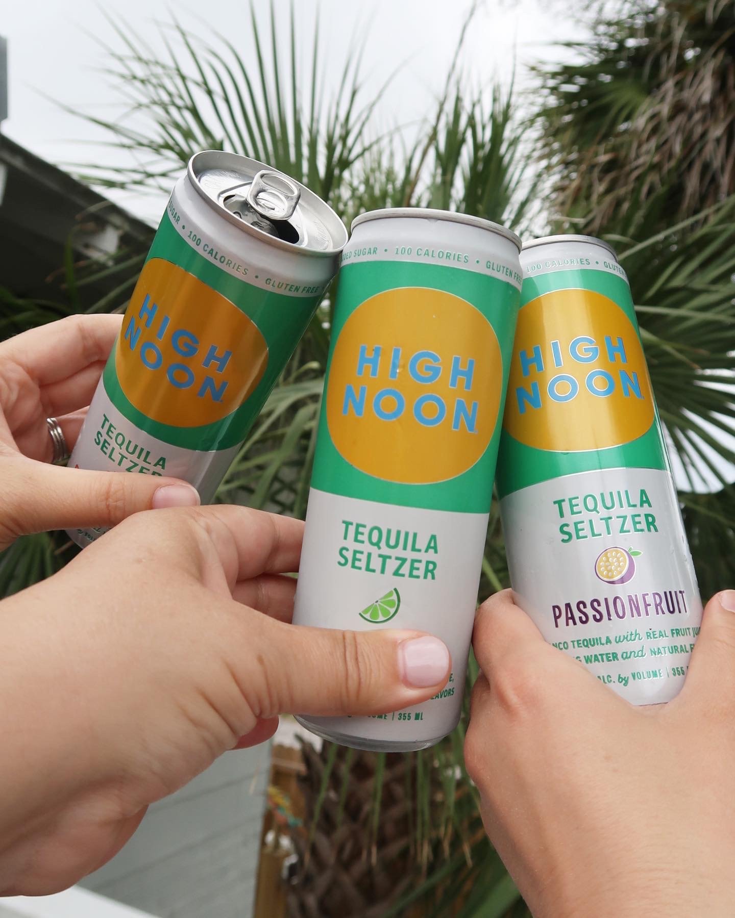 Friends toasting with High Noon seltzers