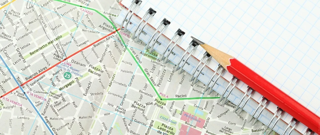 Picture of notebook, pencil and map