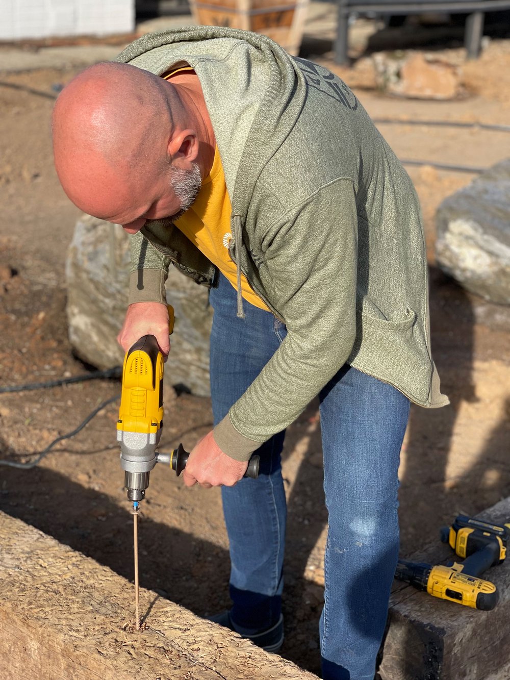  A corded pistol-grip drill is used to drive 12” ceramic screws into railroad ties for secure attachment. 