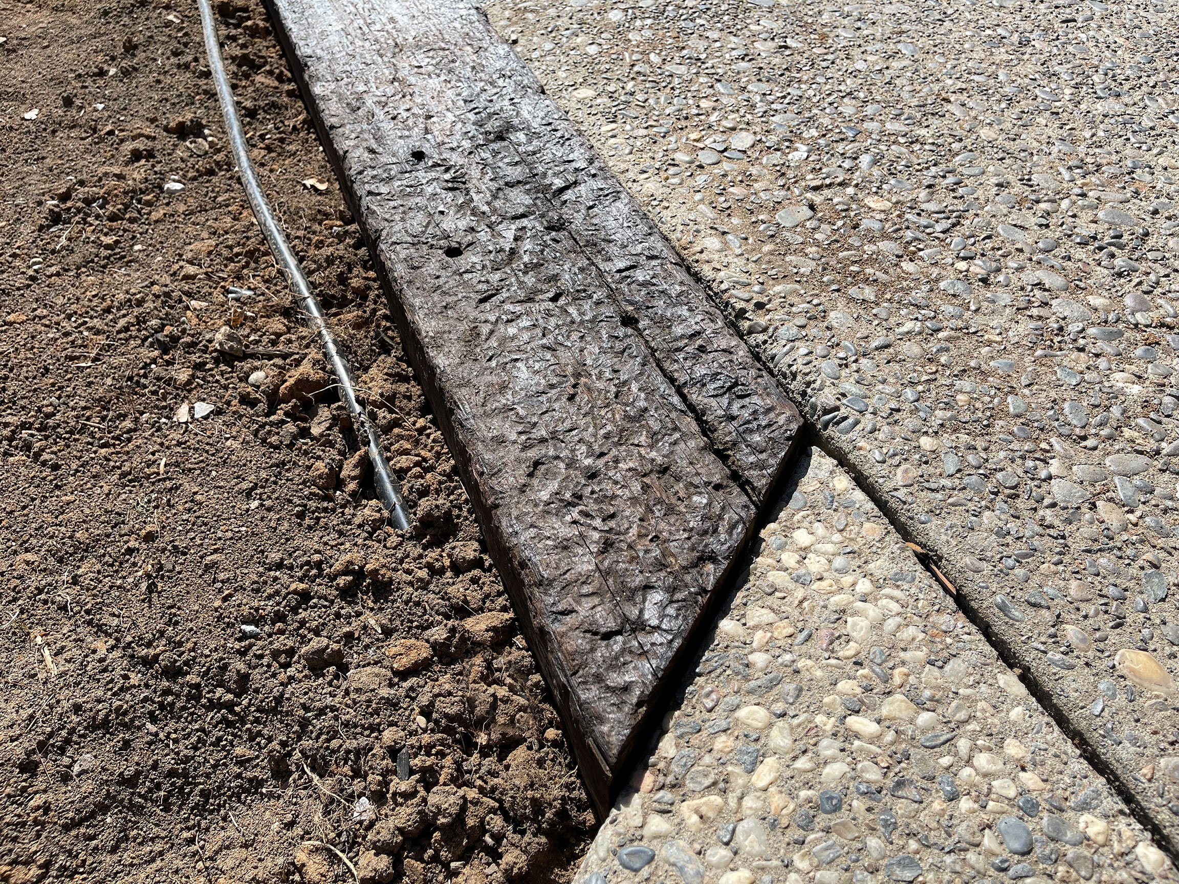  Precise angle cuts are made with a reciprocating saw to align with existing exposed aggregate walkways. 