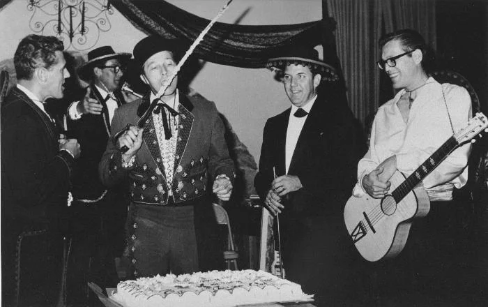 At the Triunfo Ball, 1966. L to R: John Tapking, Councilman; David Betts, former Mayor; Robert Talley, Councilman; Alex Fiore, Councilman. In the rear at the mike is Guy Runion, former owner and editor of the Conejo News.