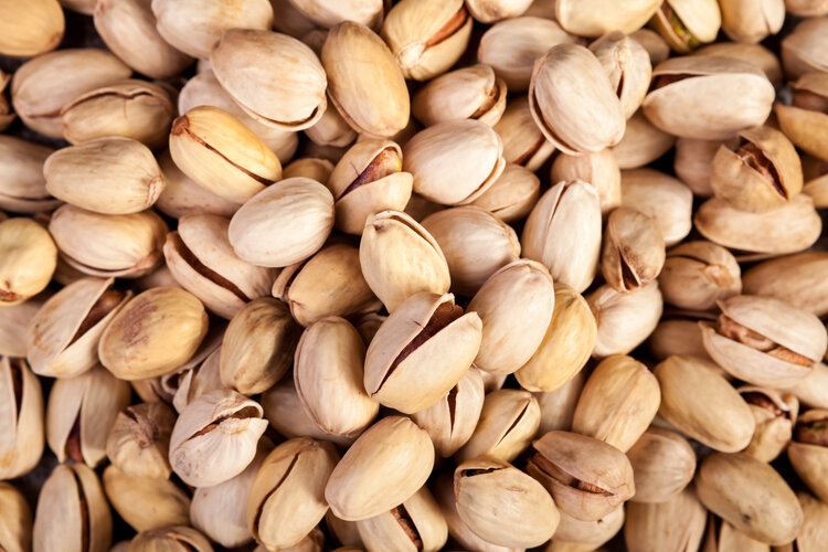 close-up-of-pistachios-on-wooden-background-in-stu-PPTDZBL.jpg