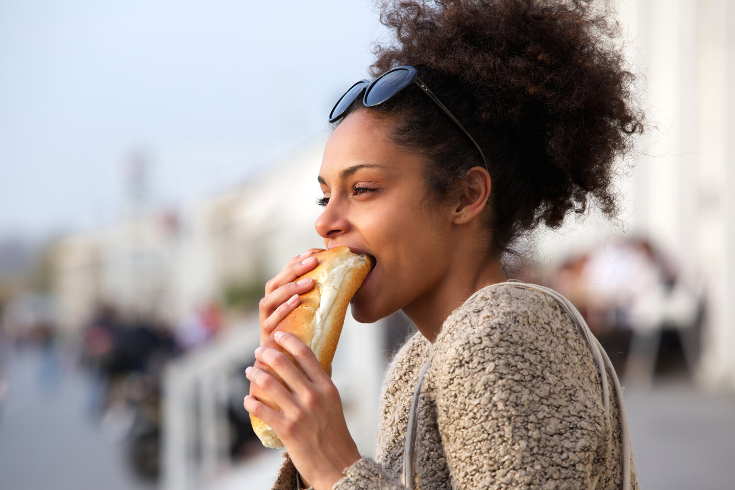 beautiful-young-woman-eating-sandwich-outdoors-P595XQW.jpg