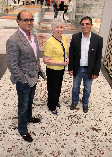 Sanjay Purohit, left, and Reza Zollanvari, right, with Art to Walk On's Eileen Hampshire, who bought the silk and oxidized wool rug the trio is posing on.