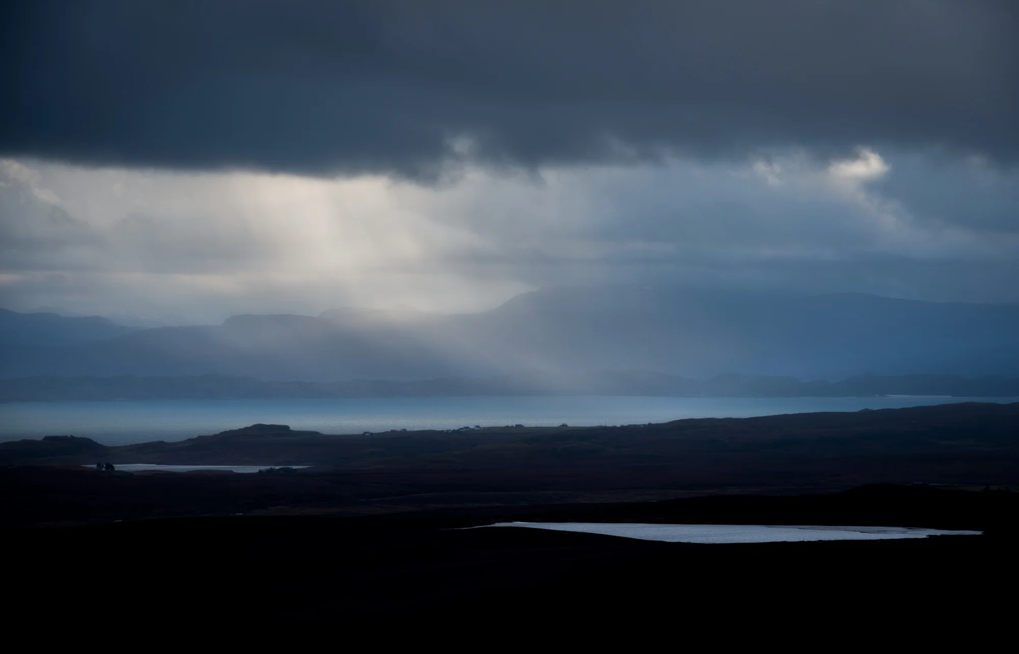 Lochans in blue with squall over Applecross