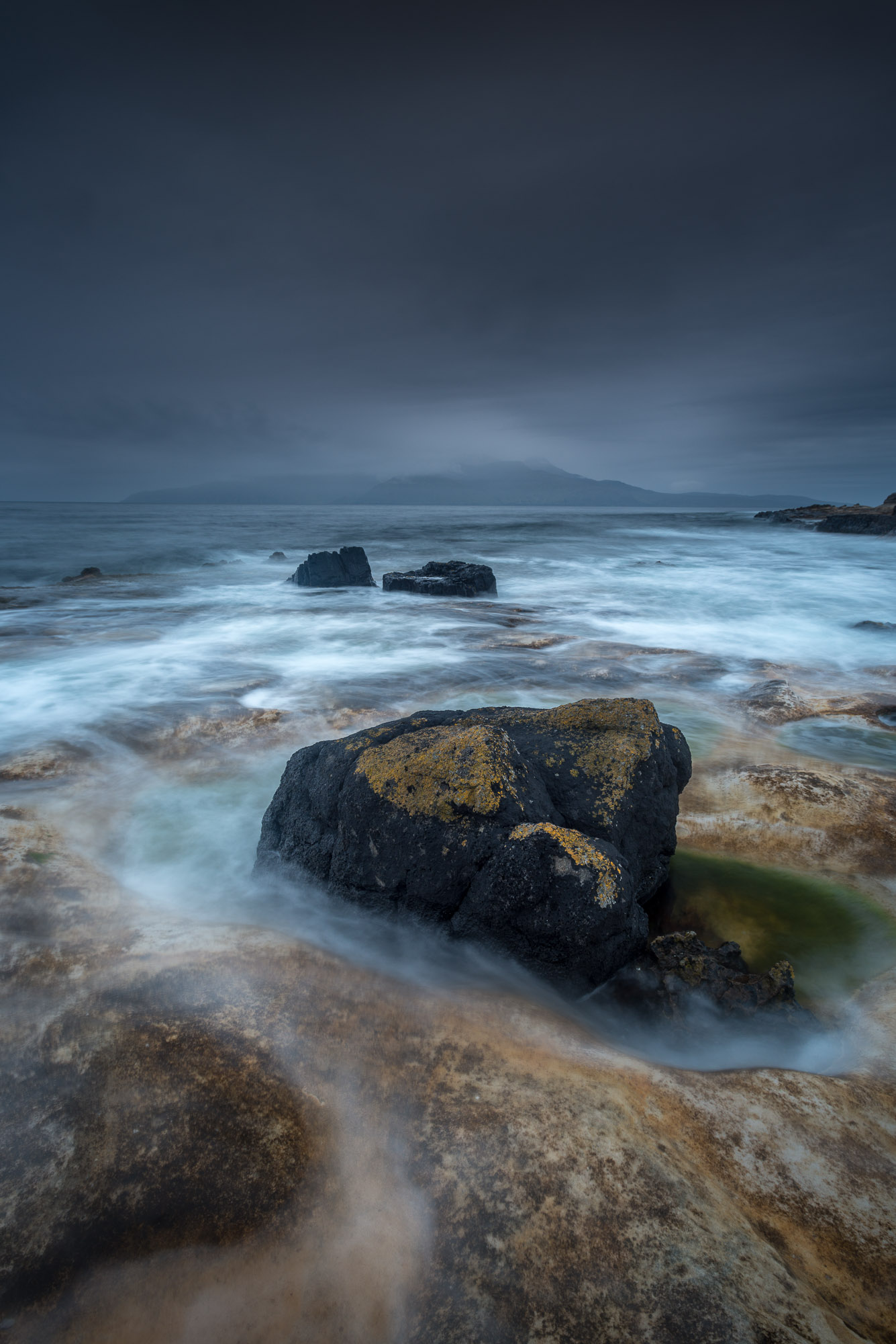 Laig rocks at twilight high tide and Rum.jpg