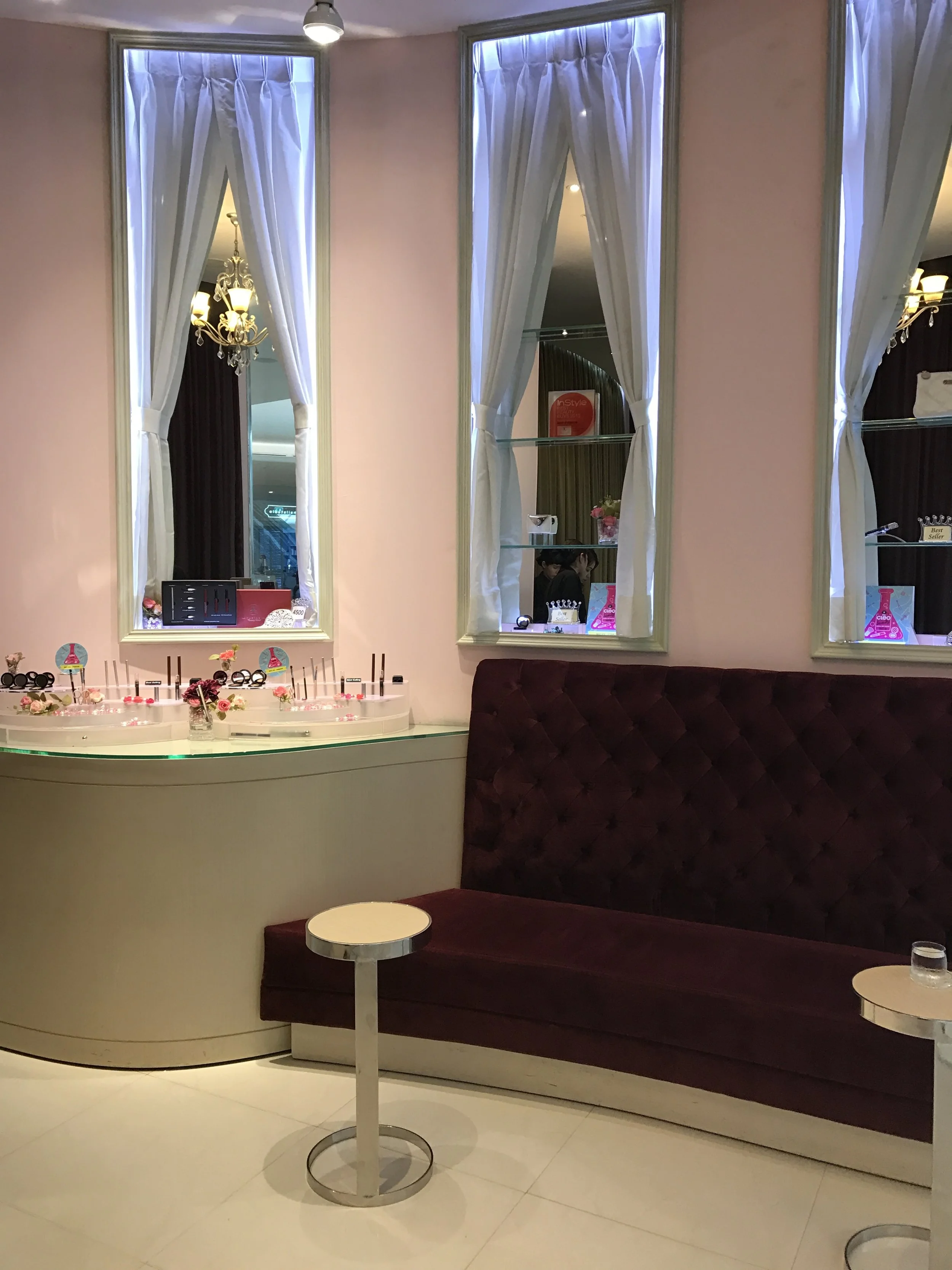 Plush purple sofas in the waiting area and a selection of their make-up products on the counter
