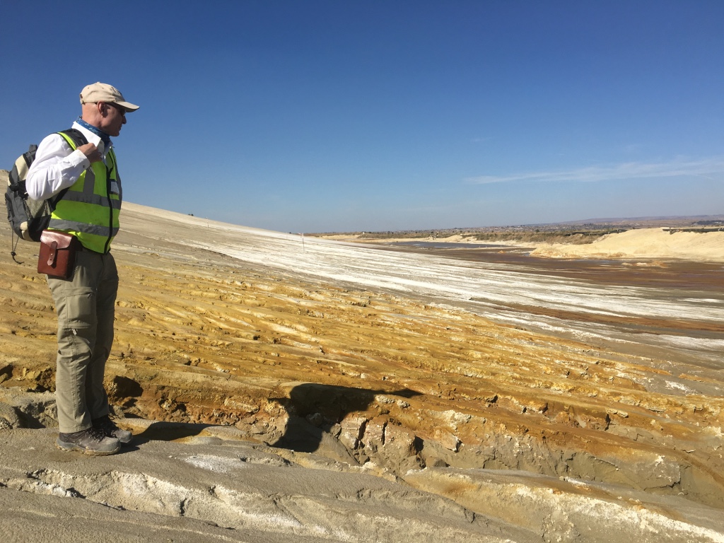 Collecting samples of acid seepage from gold mine tailings