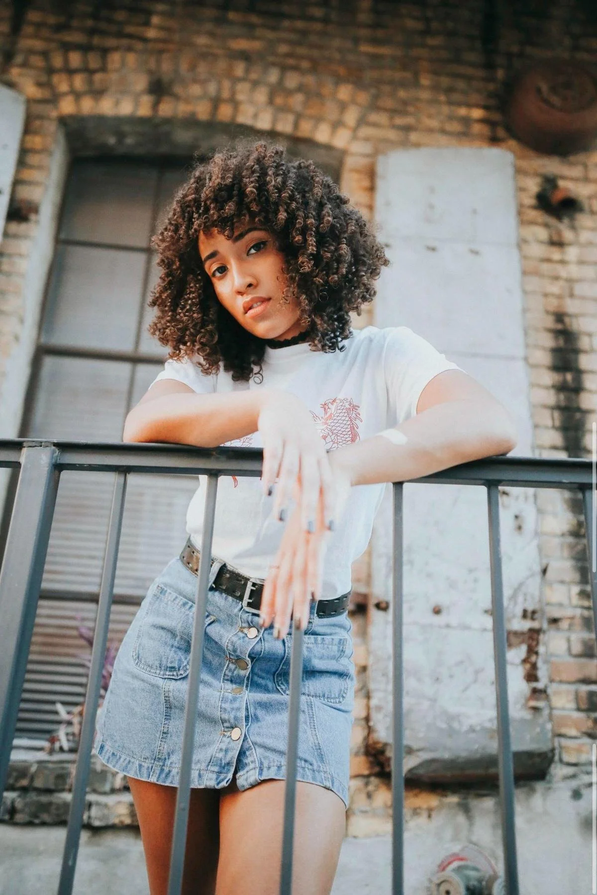 Portrait of a woman with curly hair against a rustic doorway, Orkams collab series