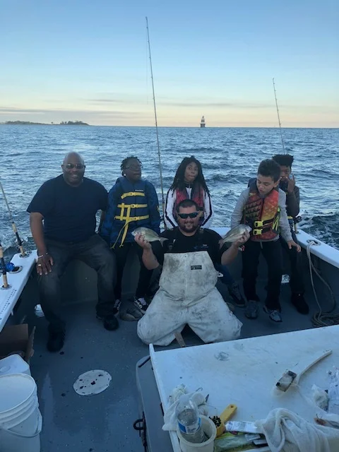 Brian Alert, Carver’s Chief Program Officer, with four Carver students and the boat captain admiring the catch of the day!