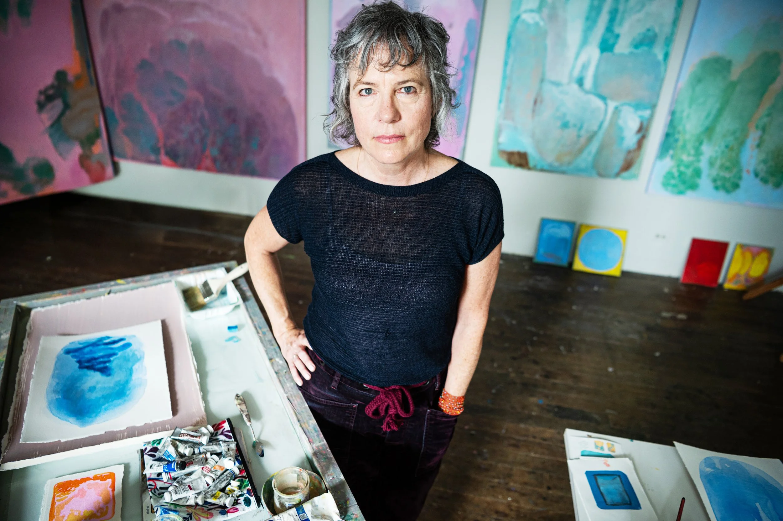 artist Anne Hayden Stevens in her studio surrounded by paintings