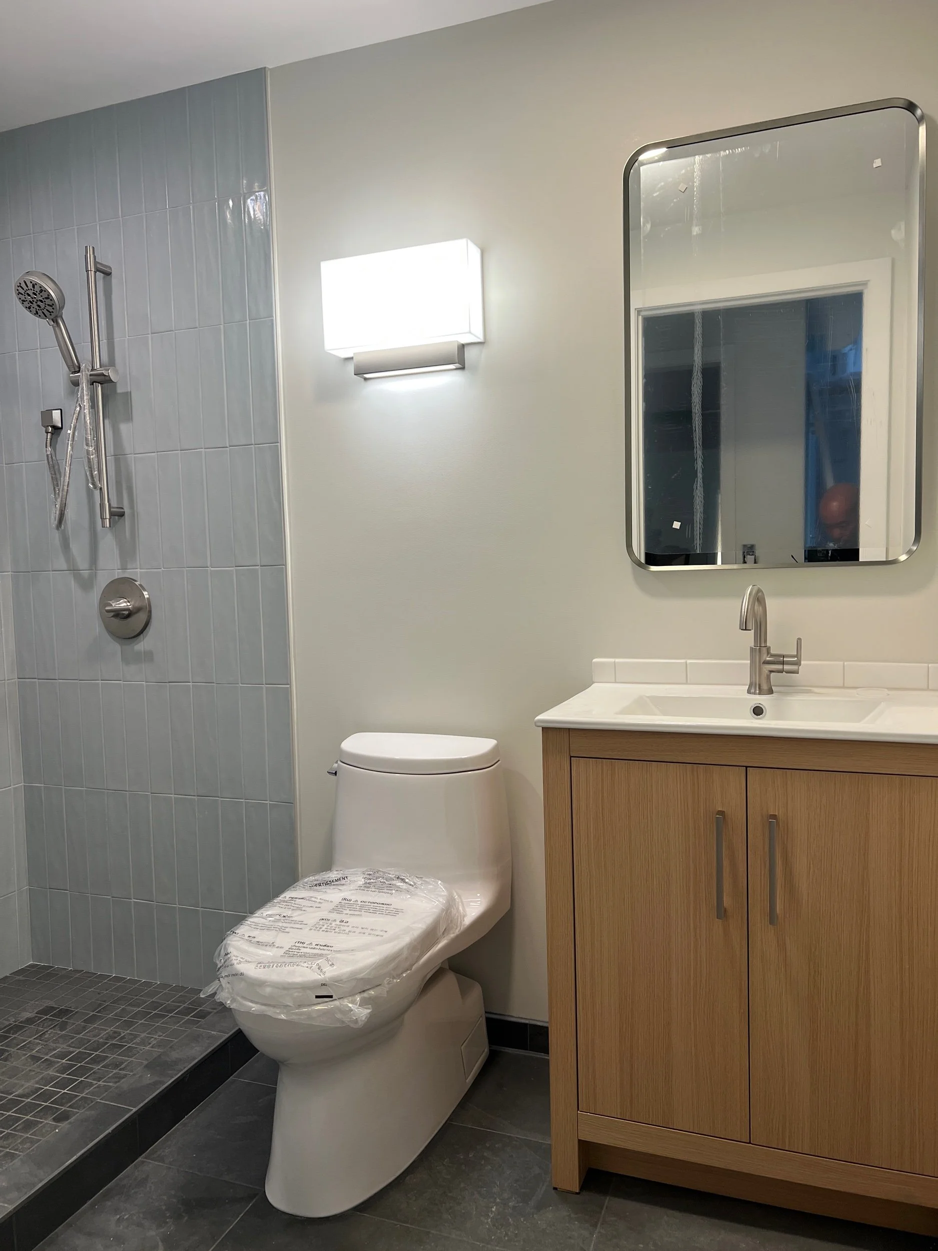  The Studio apartment bathrooms feature warm wood finishes paired with vibrant tiles for a balance of coziness and fun. 