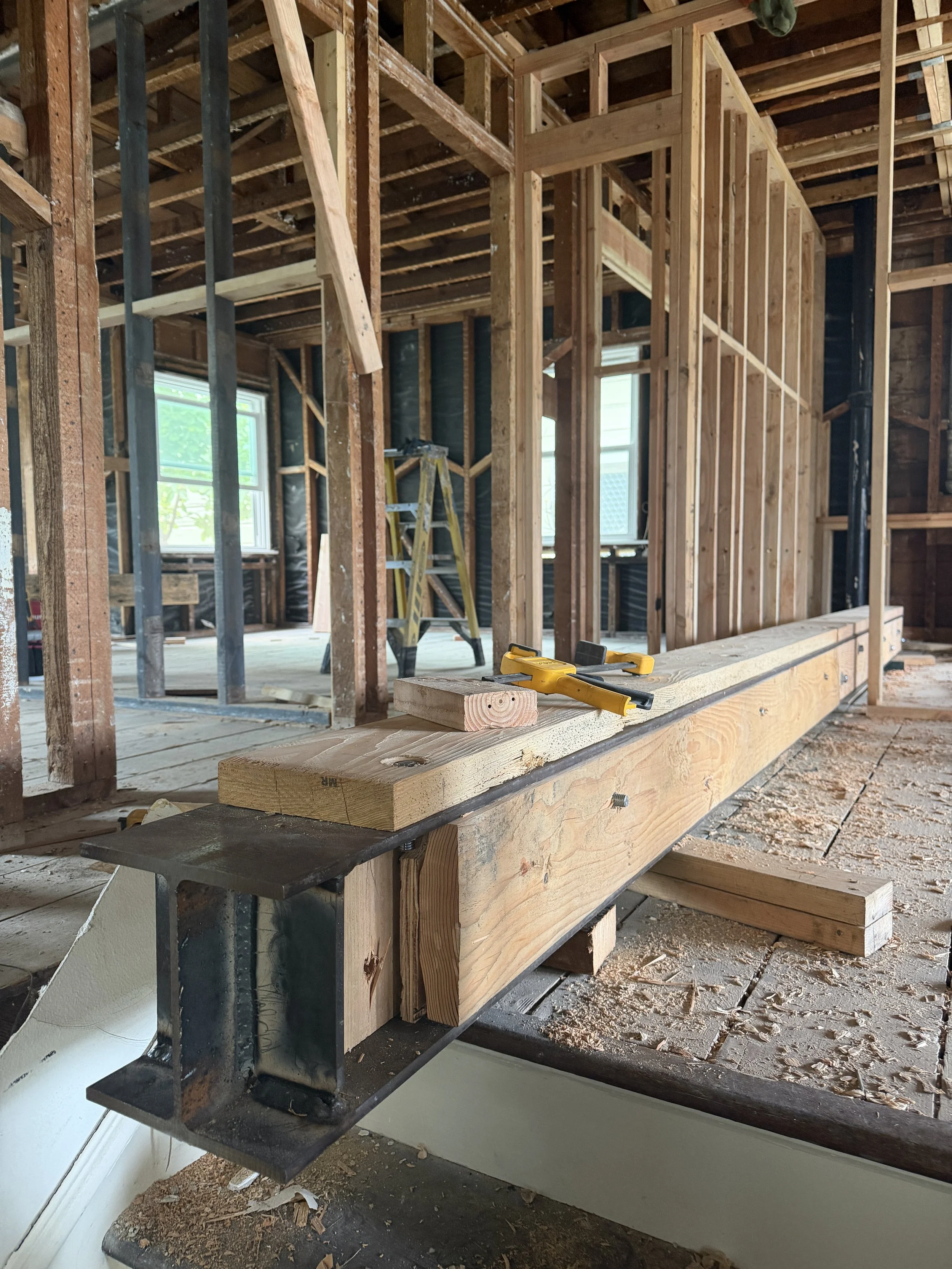 The steel beam needs to be packed with wood so the existing wood joists can hang on the sides.