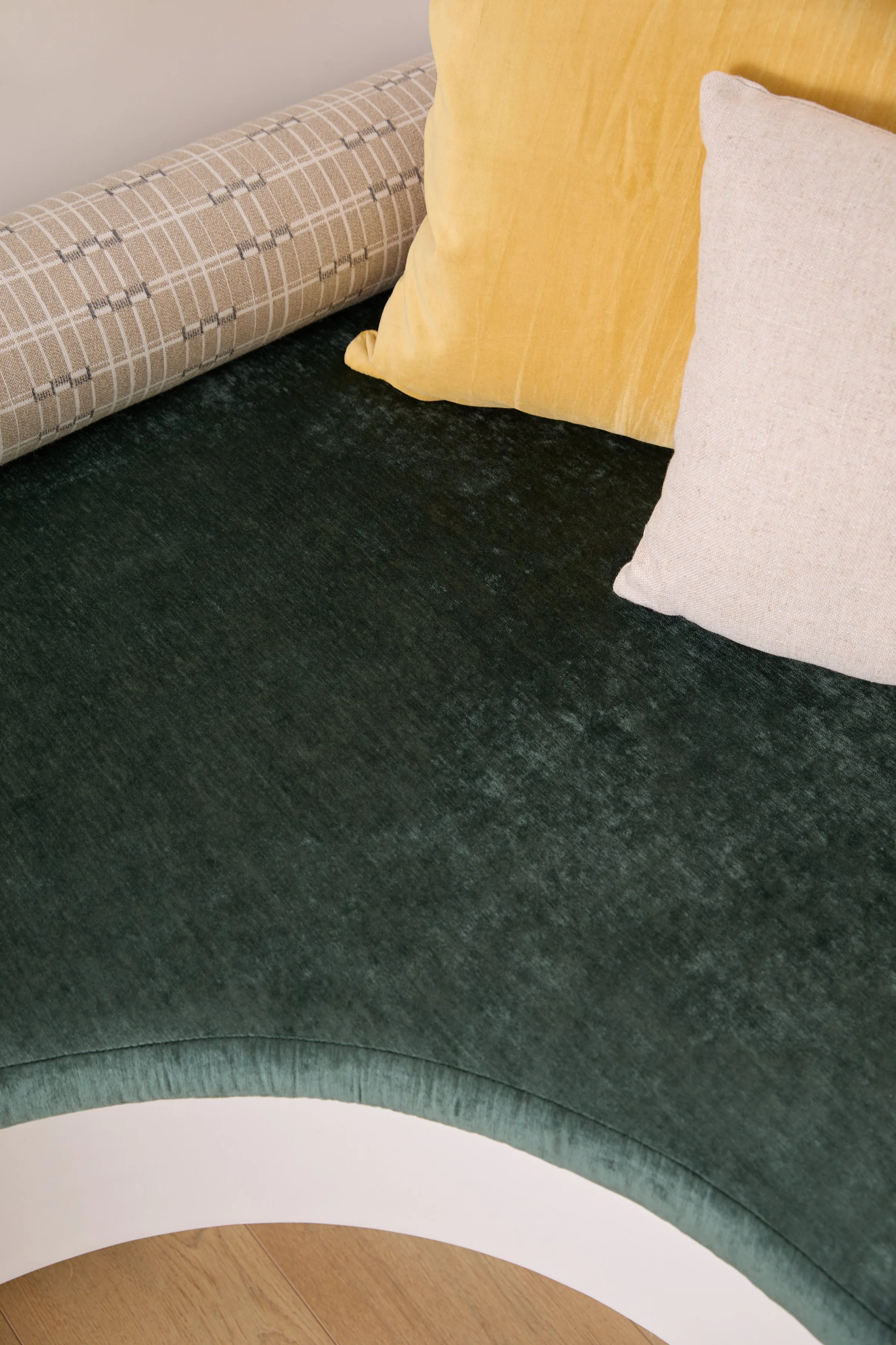 Custom curved velvet banquette seat cushion paired with a decorative patterned bolster pillow.