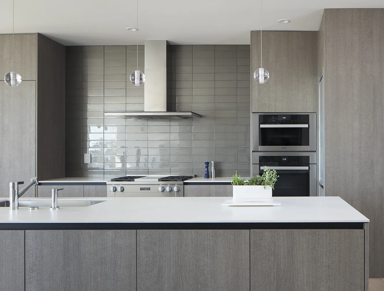 The grey palette is extended to the back splash tiles.
