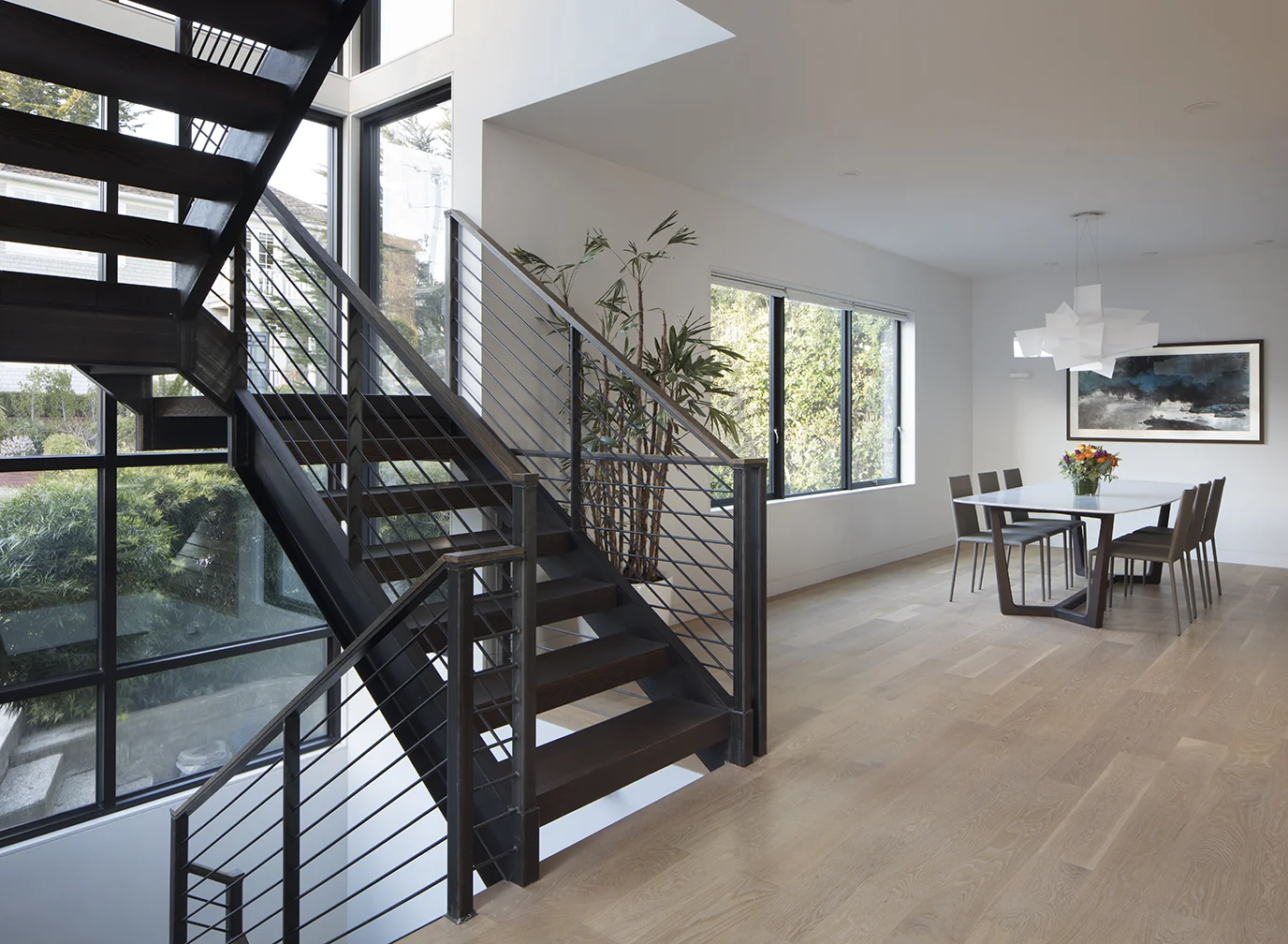 The dark finish on the staircase adds drama to the kitchen and dining areas.