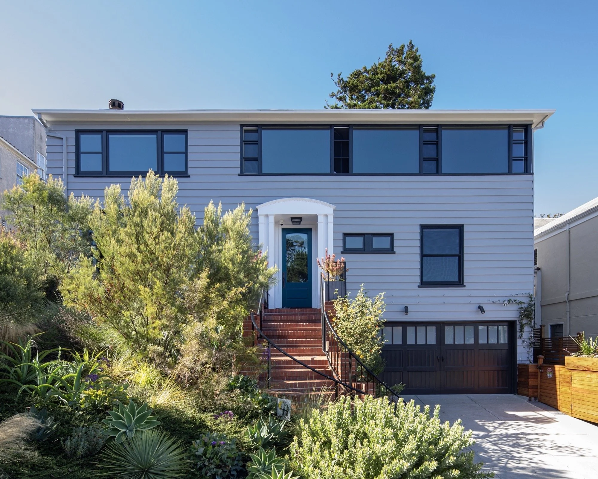  The front of the home, with a sloping landscape on the left. 