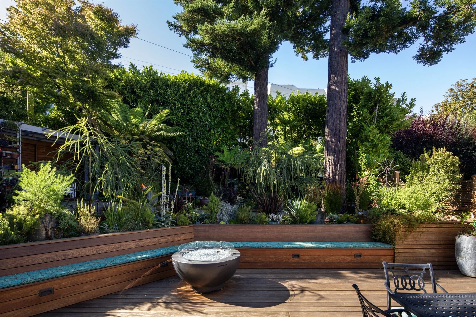  A wooden bench wraps the patio, and a firepit. 